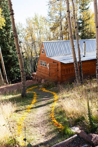 A-frame structure sits on a hill in the colorado forest, used for micro weddings and elopements