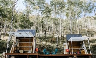 A-frame structure sits on a hill in the colorado forest, used for micro weddings and elopements