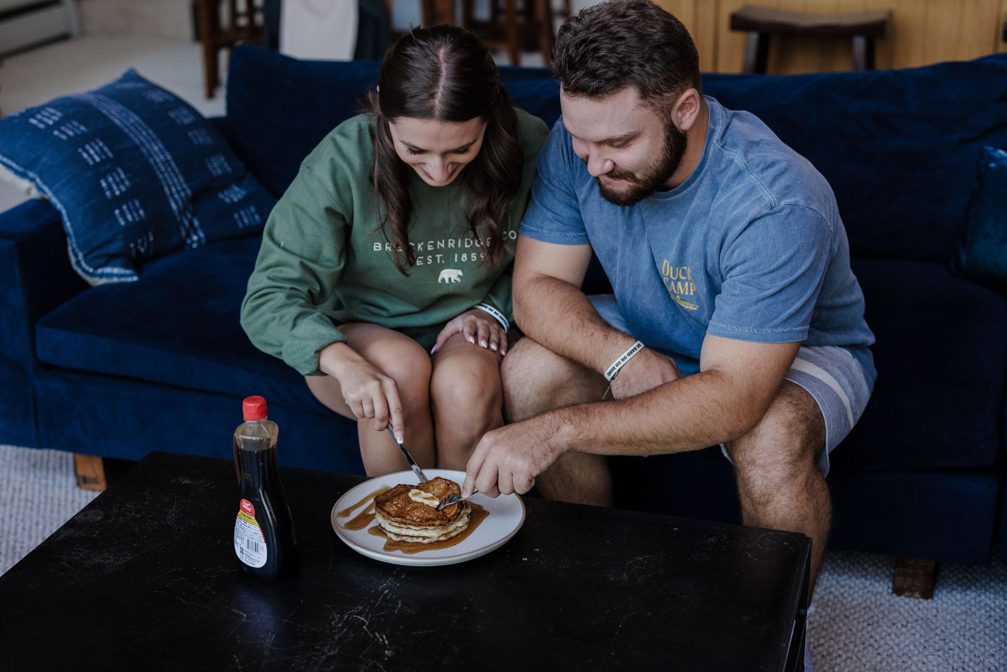 bride and groom cut into a stack of pancakes in airbnb after colorado summer elopement wedding
