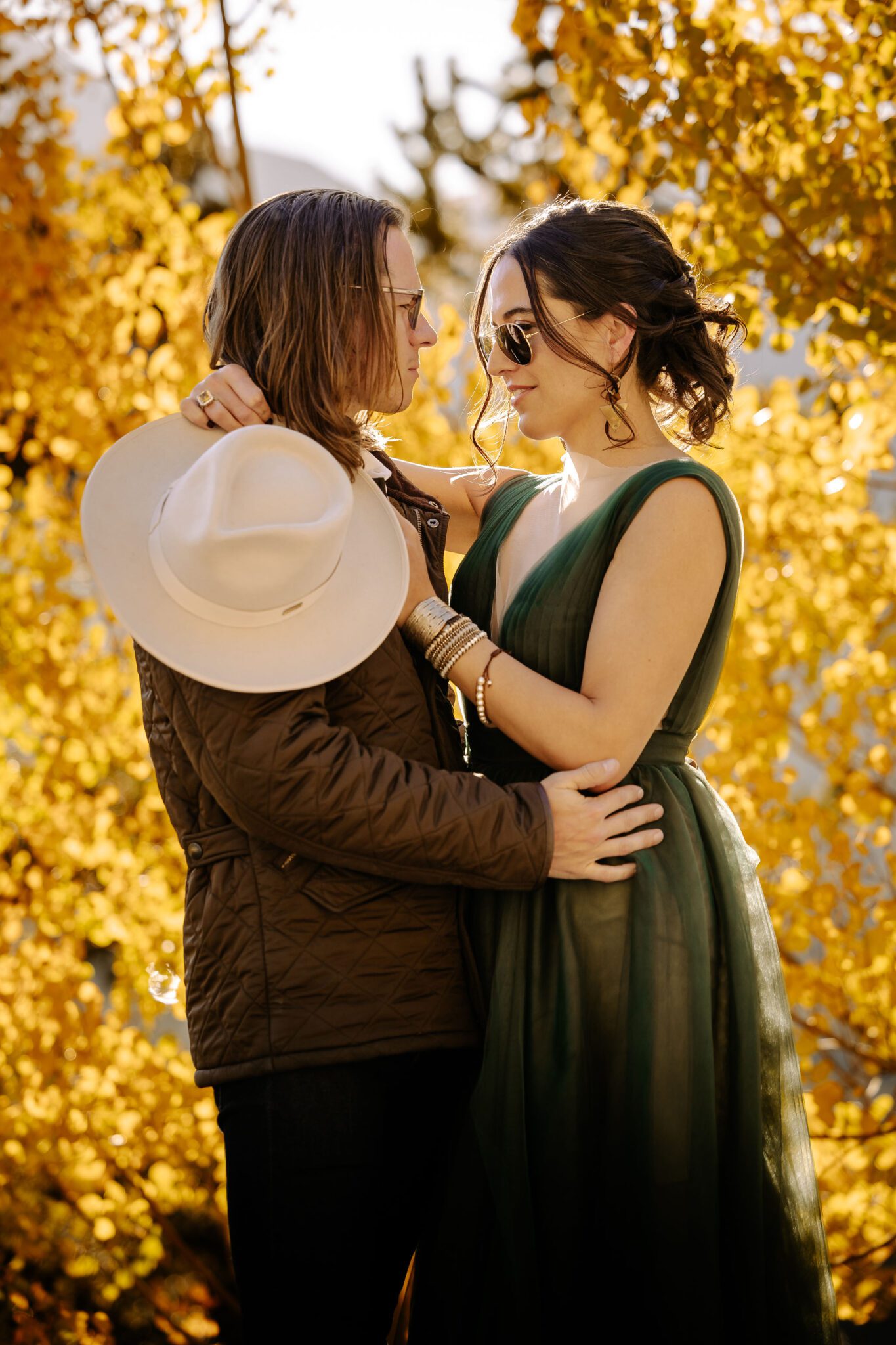 bride and groom pose for photographer at colorado fall wedding vanue