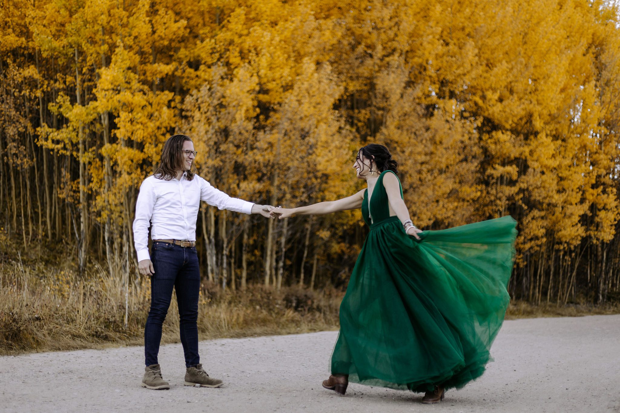 bride and groom pose for photographer at colorado fall wedding vanue