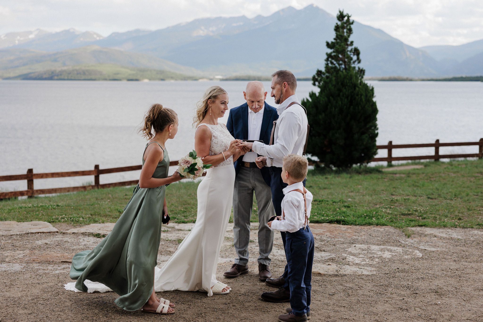 bride puts ring on grooms finger during their mountain lake wedding in breckenridge