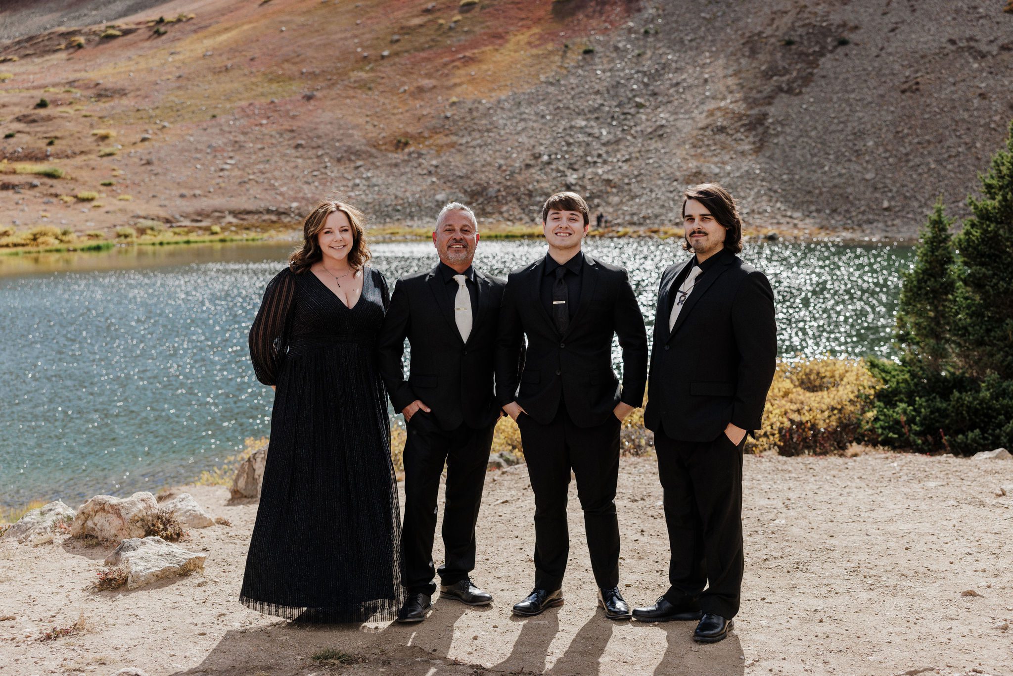 groom and family stand by lake during colorado wedding photos