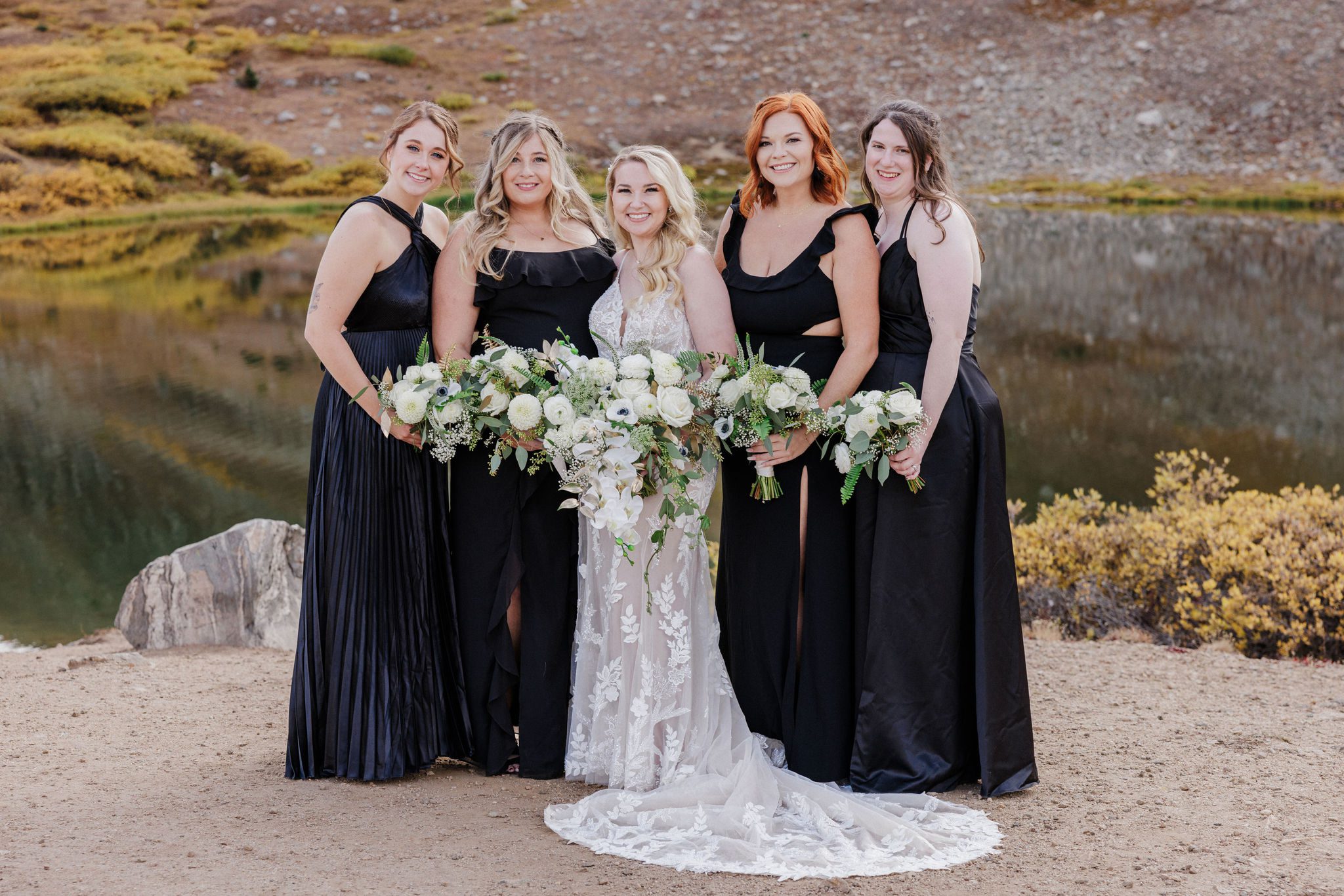 bride and family stand by lake during their mountain lake wedding in colorado