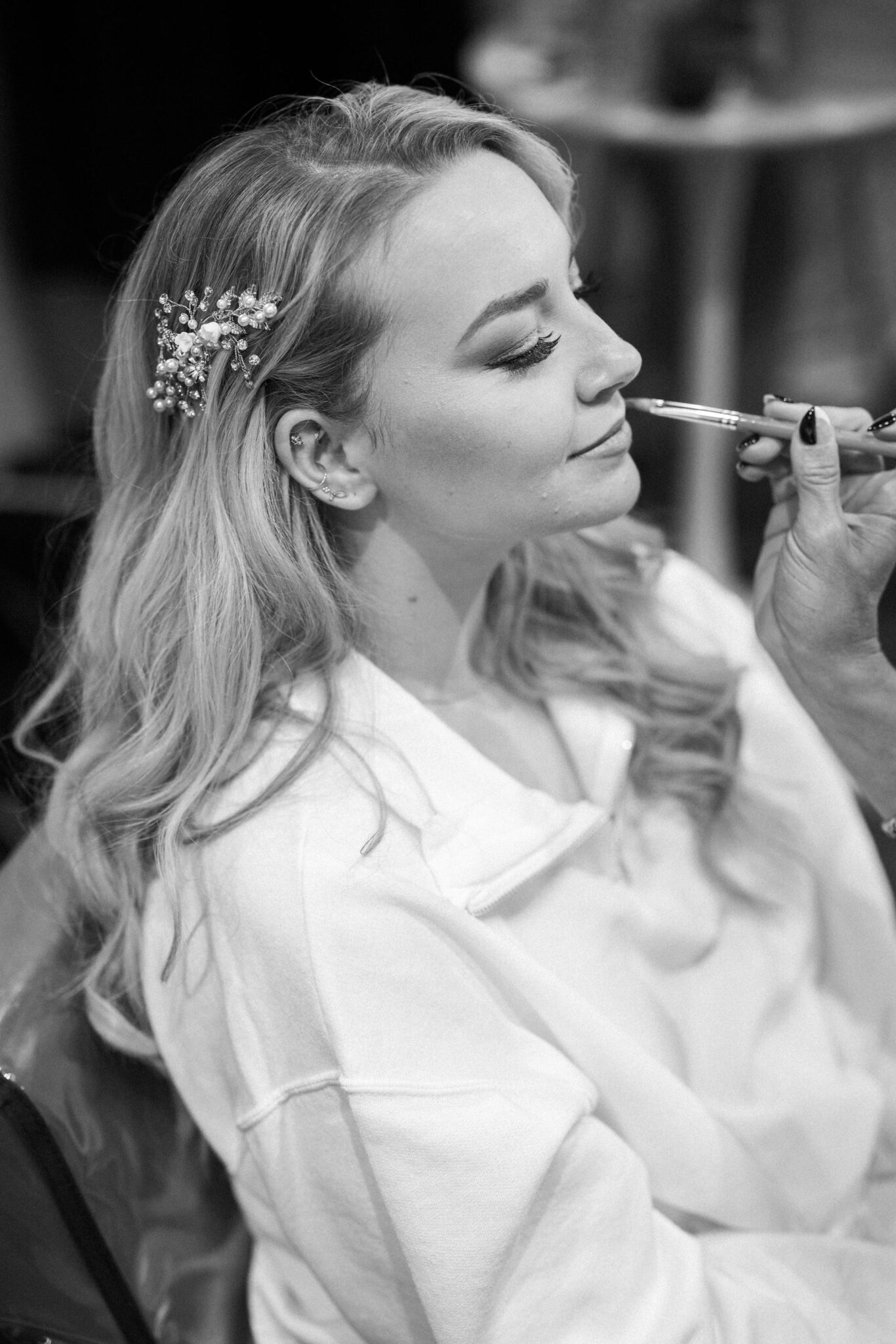 bride sits as she gets her makeup done before her colorado mountain lake wedding