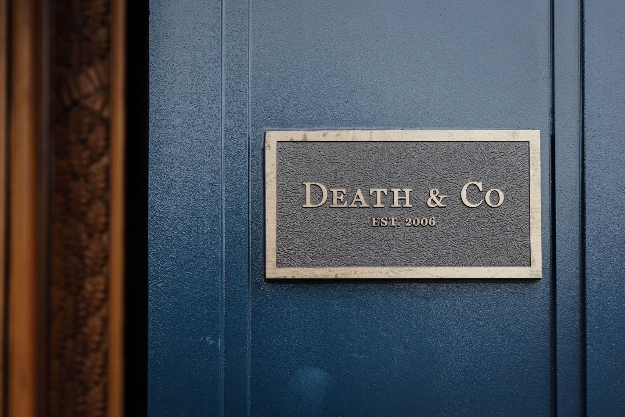 'Death & Co ' brass sign outside of colorado summer wedding venue's reception area