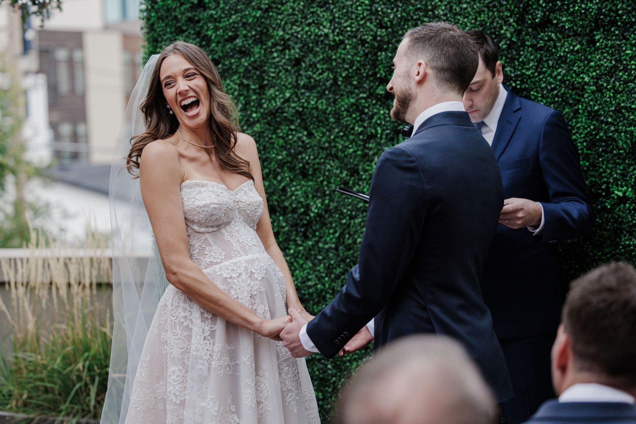 bride and groom laugh during micro wedding ceremony at the ramble hotel rooftop