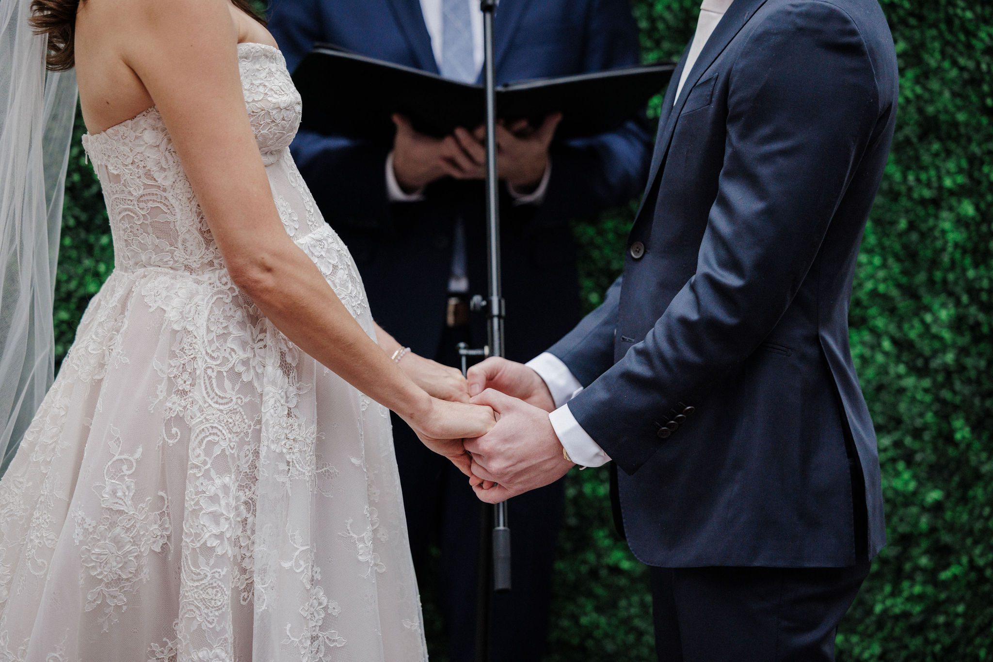 bride and groom hold hands during micro wedding ceremony