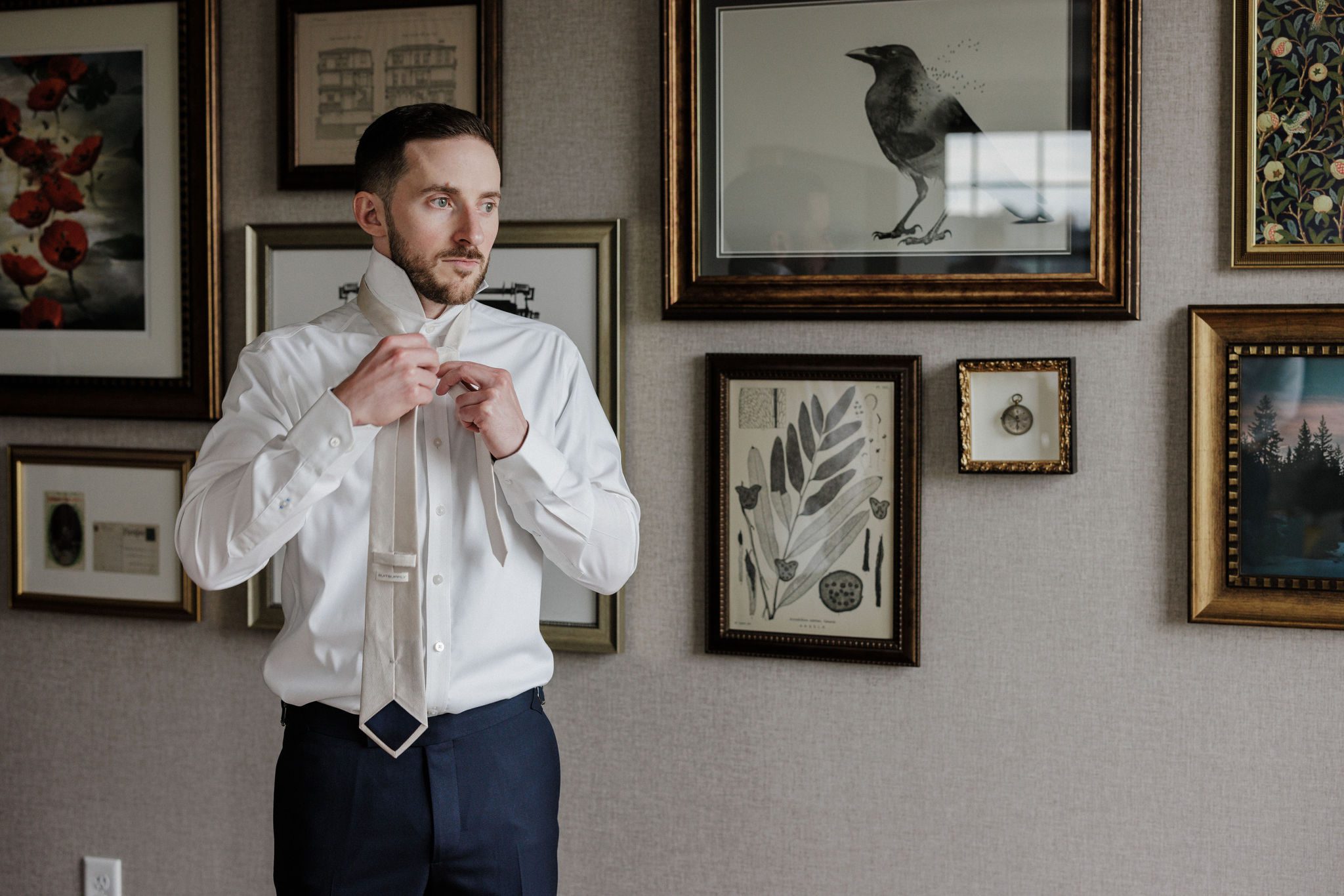 groom ties tie while getting ready at a denver micro wedding wedding venue, the ramble hotel