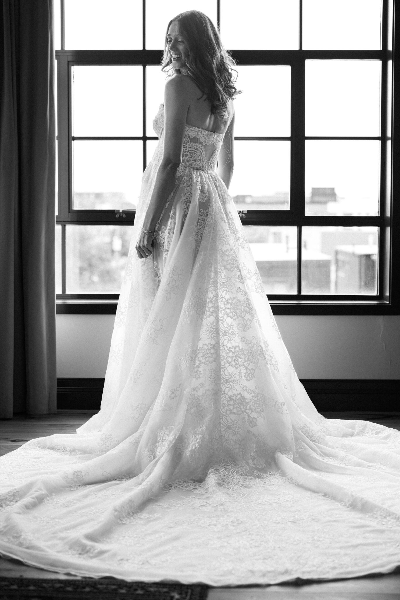 bride stands in front of window in bridal suite at denver micro wedding wedding venue, the ramble hotel