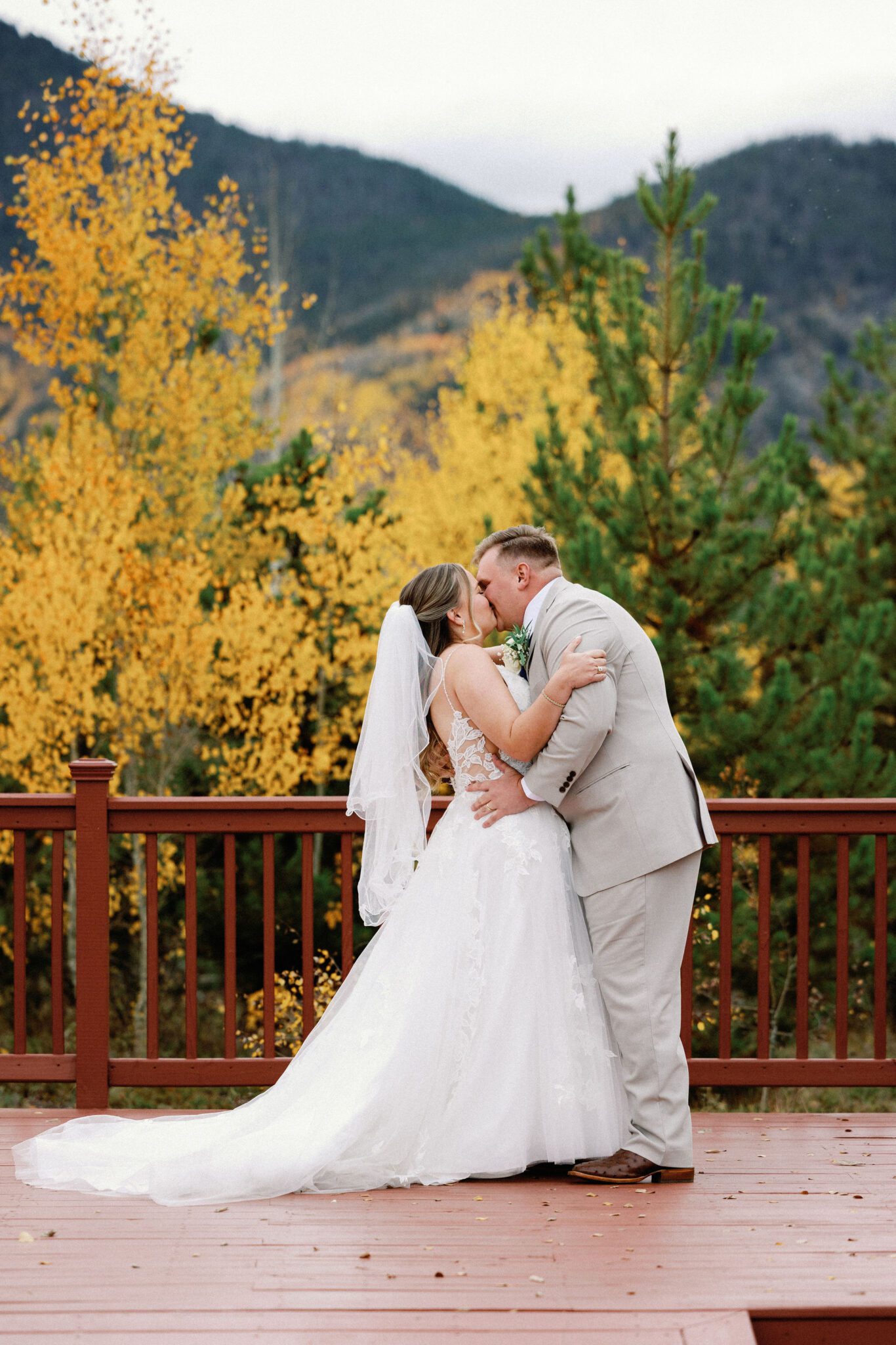 bride and groom kiss in front of yellow aspens during fall micro wedding in colorado