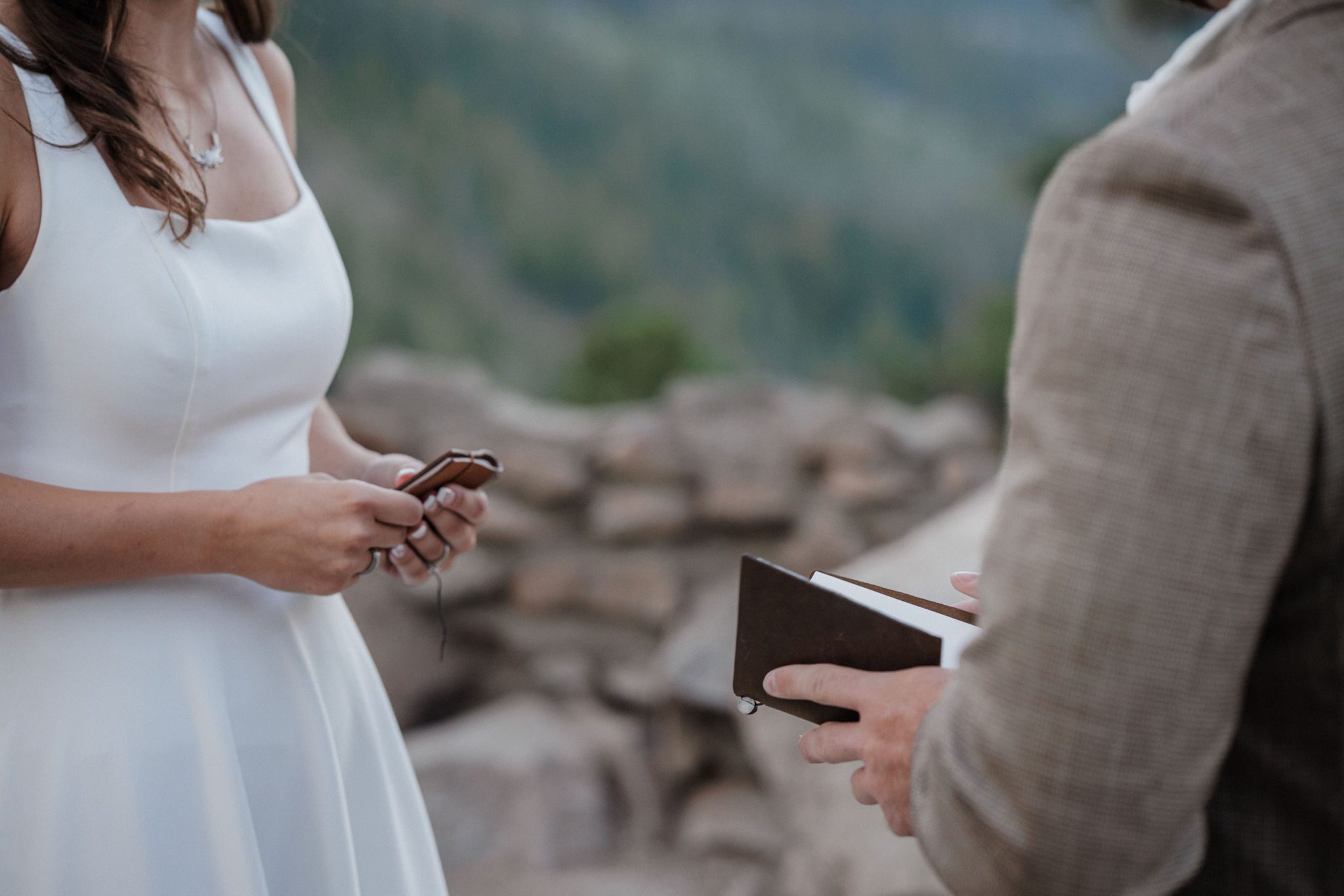 bride and groom hold wedding vow books during colorado elopement in the mountains