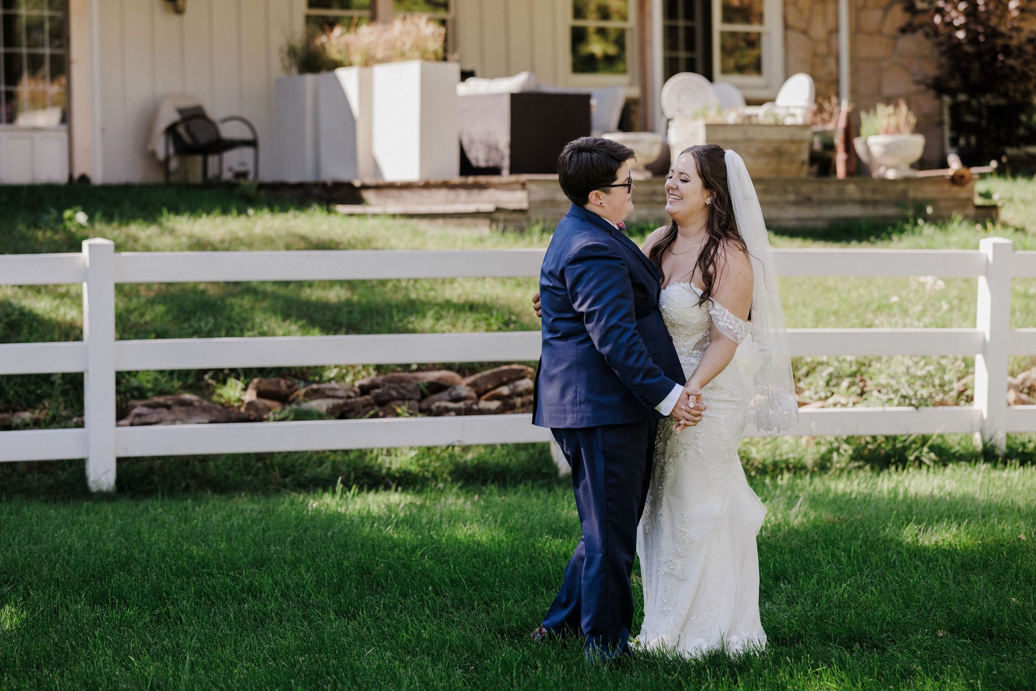 two brides smile and share a first dance during their backyard wedding at an airbnb