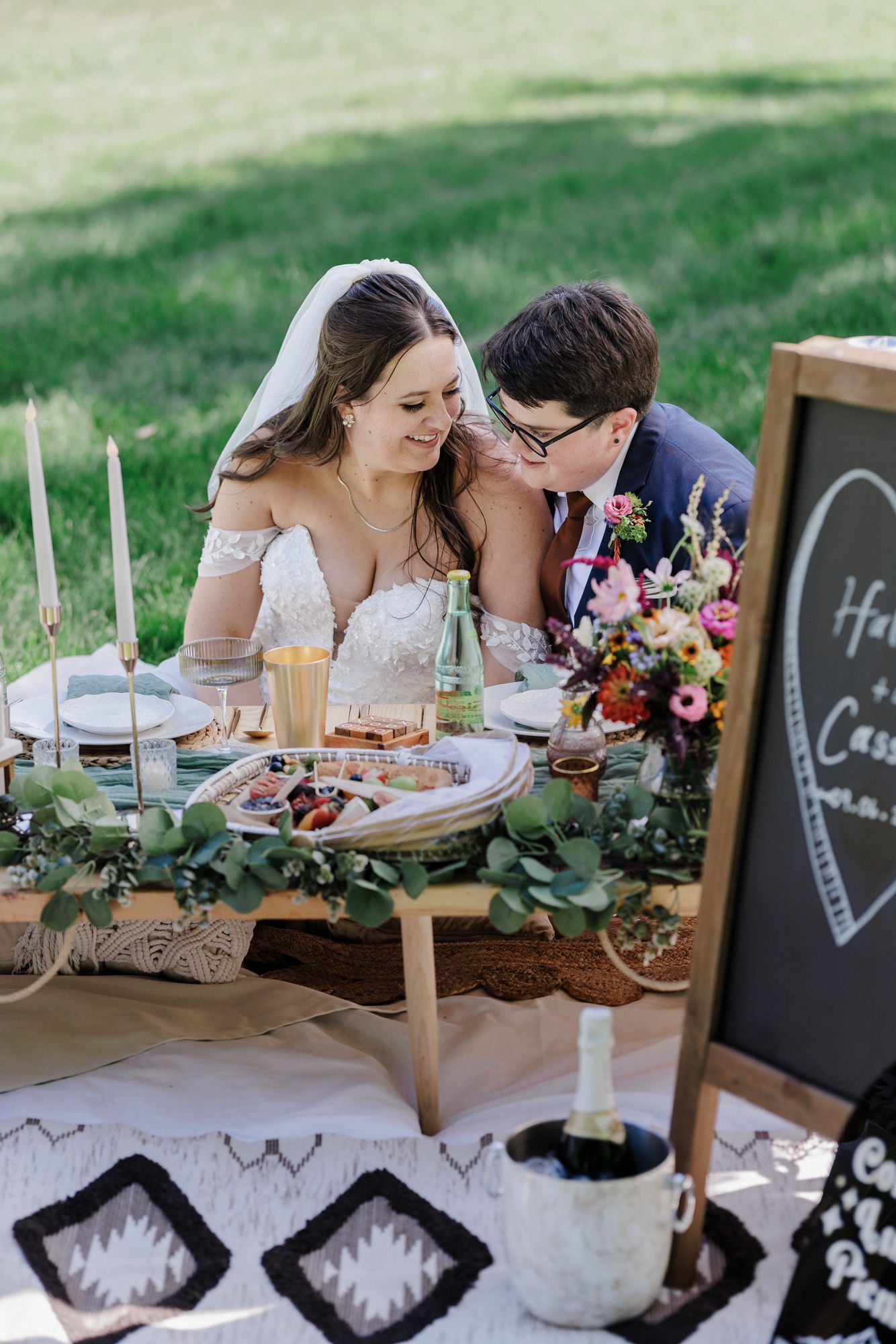 two brides sit at their elopement luxury picnic