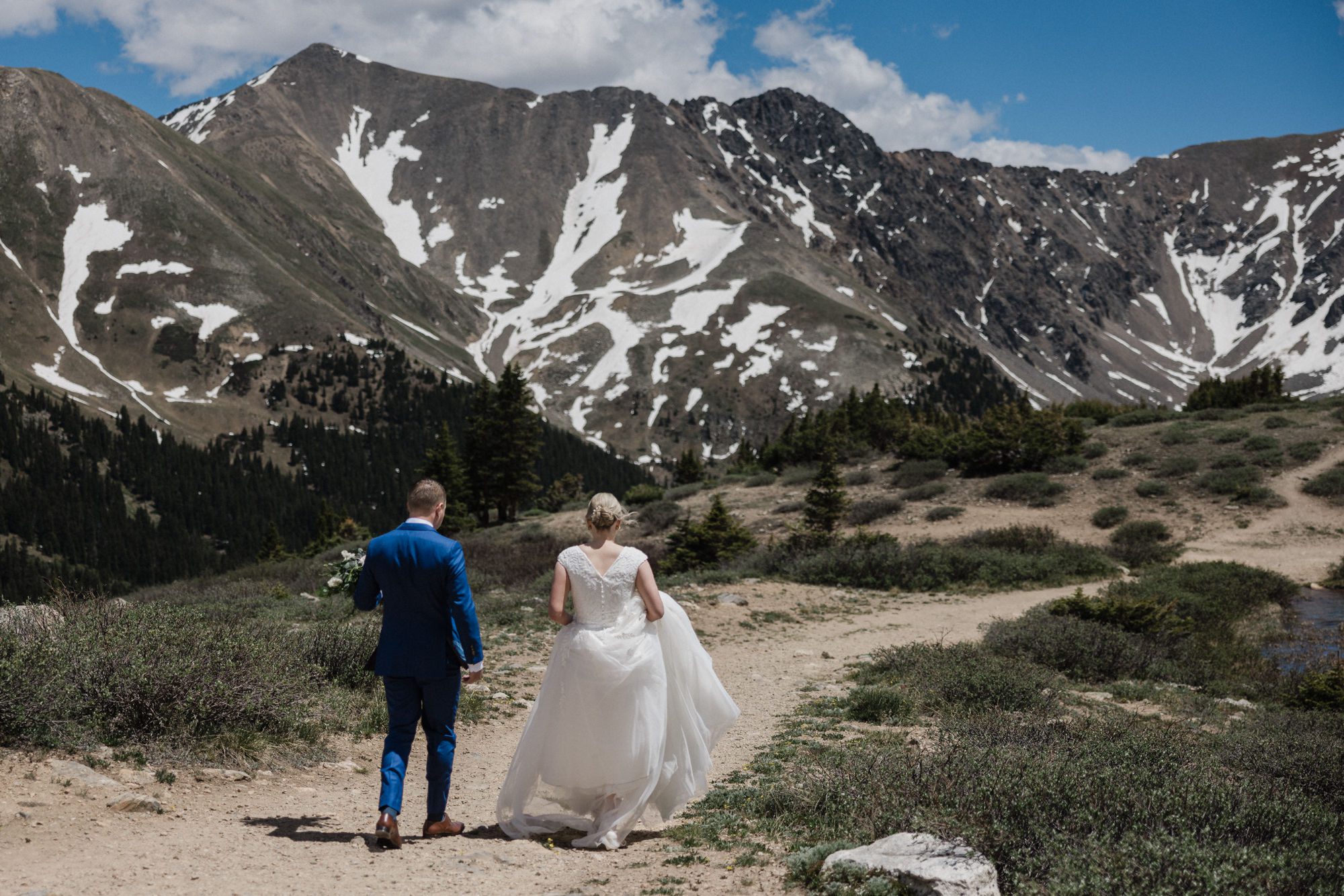 bride and groom hike in the colorado mountains