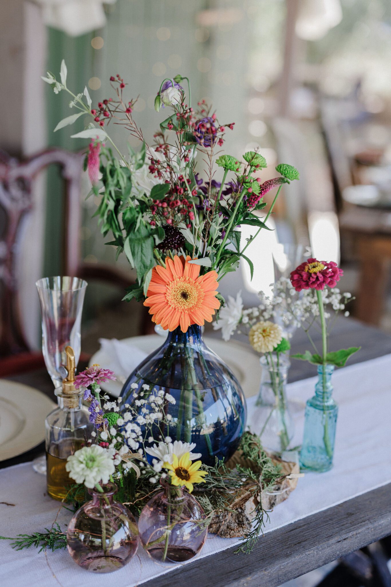 florals in vases sit on table at backyard wedding