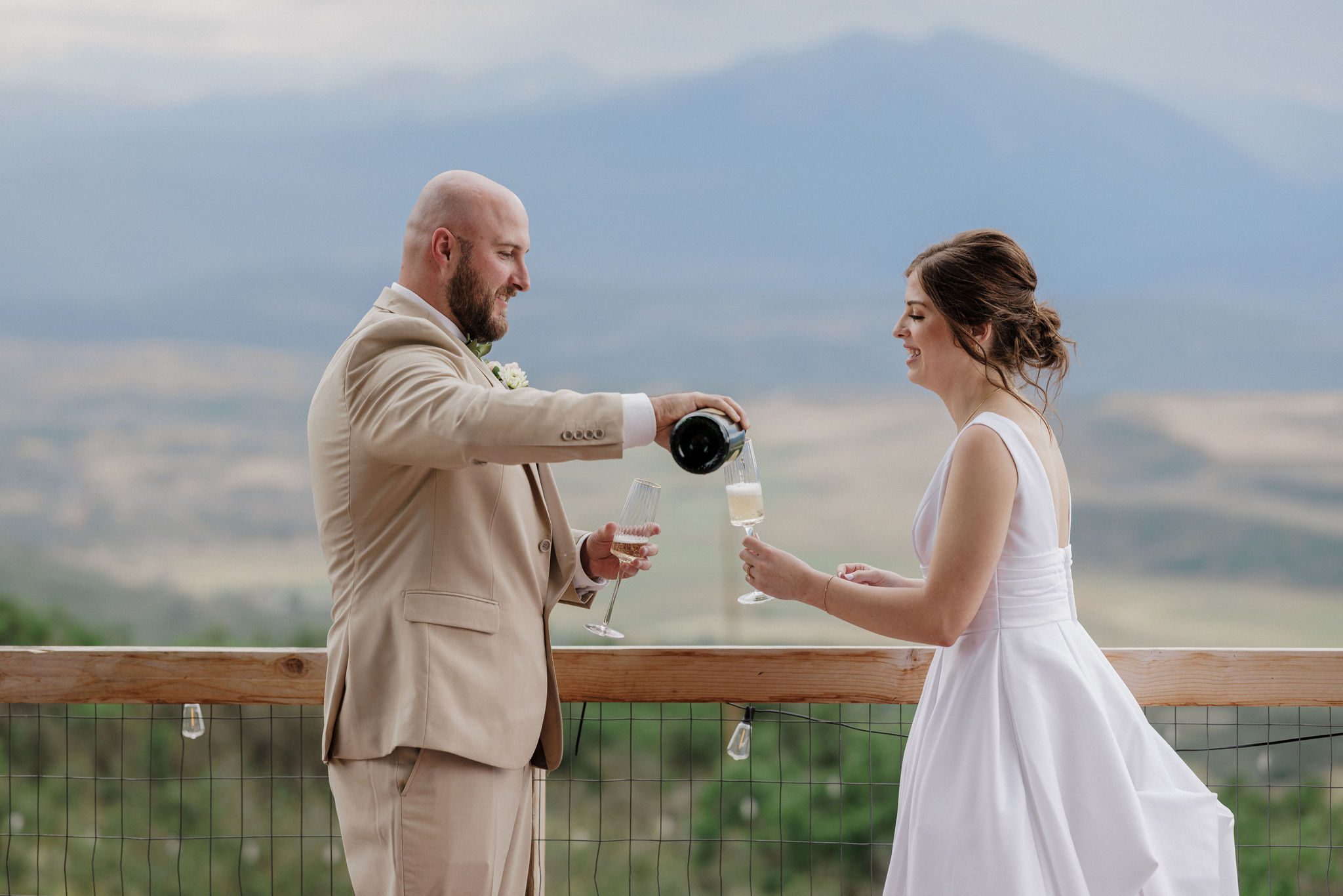 bride and groom pour champagne during backyard wedding