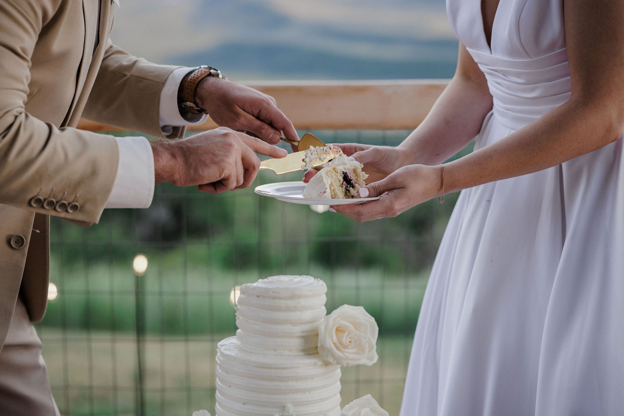 bride and groom get a slice of wedding cake during their backyard micro wedding