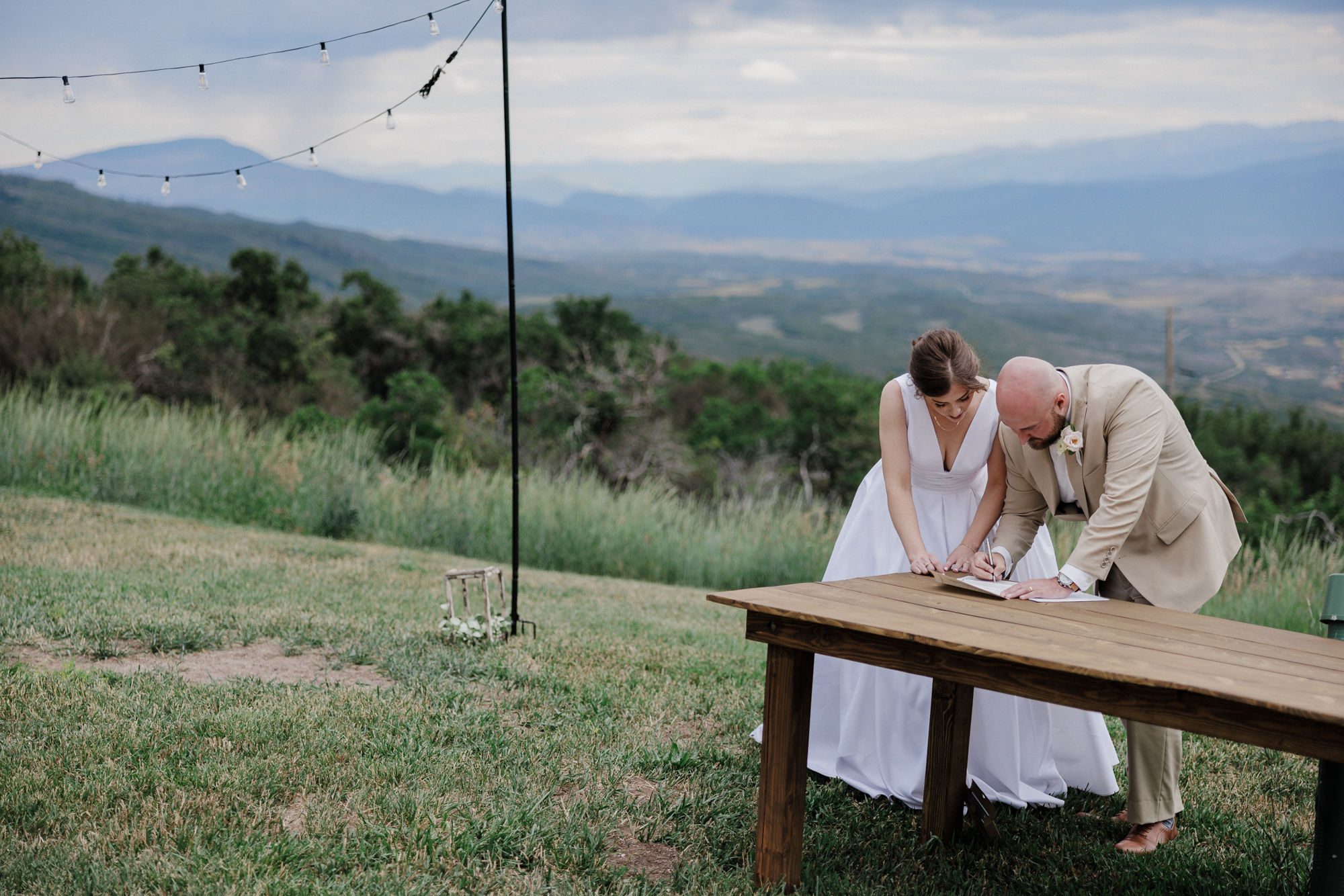 bride and groom sign marriage license in the backyard of their airbnb