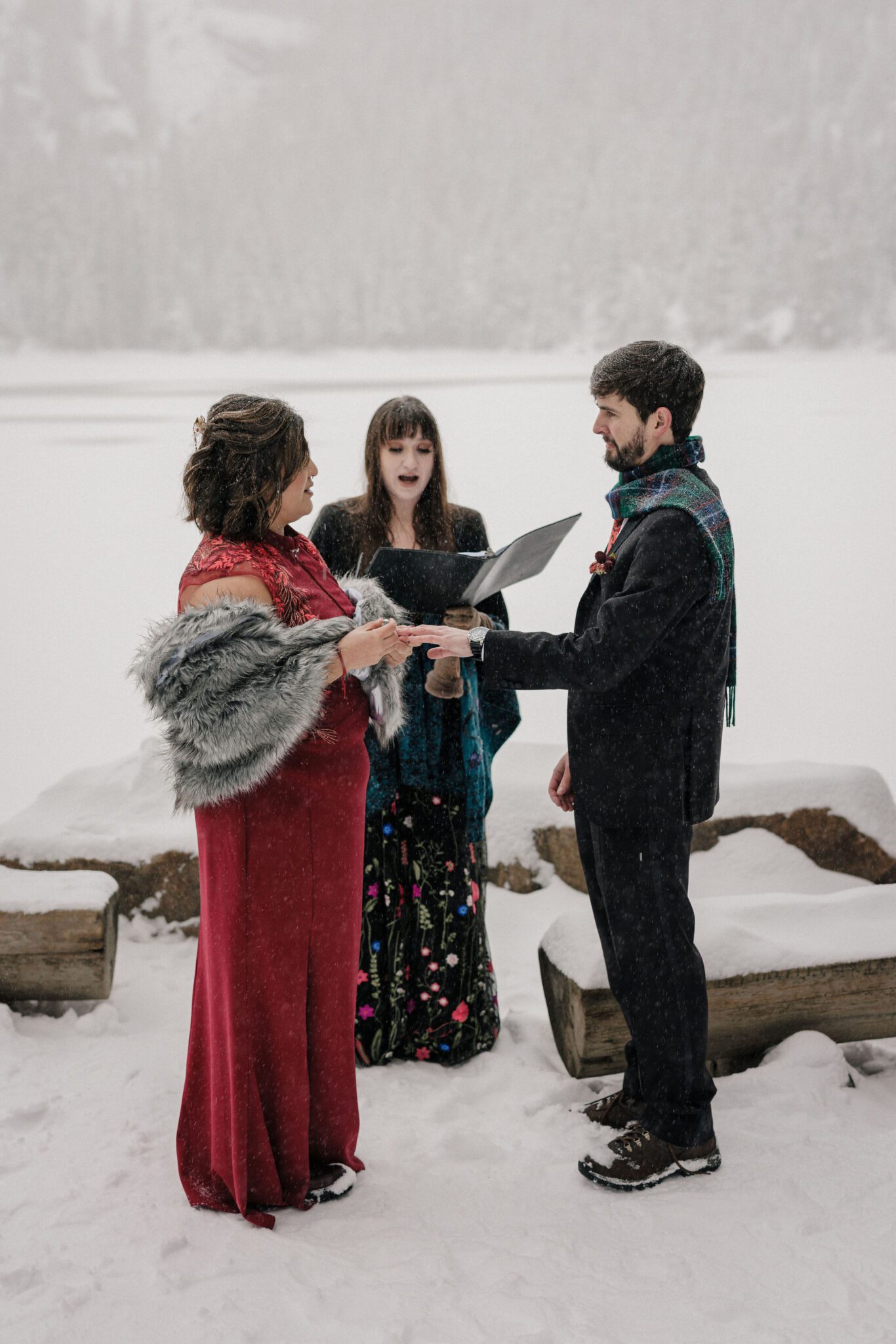 bride and groom say wedding vows and bride puts ring on grooms finger during colorado elopement