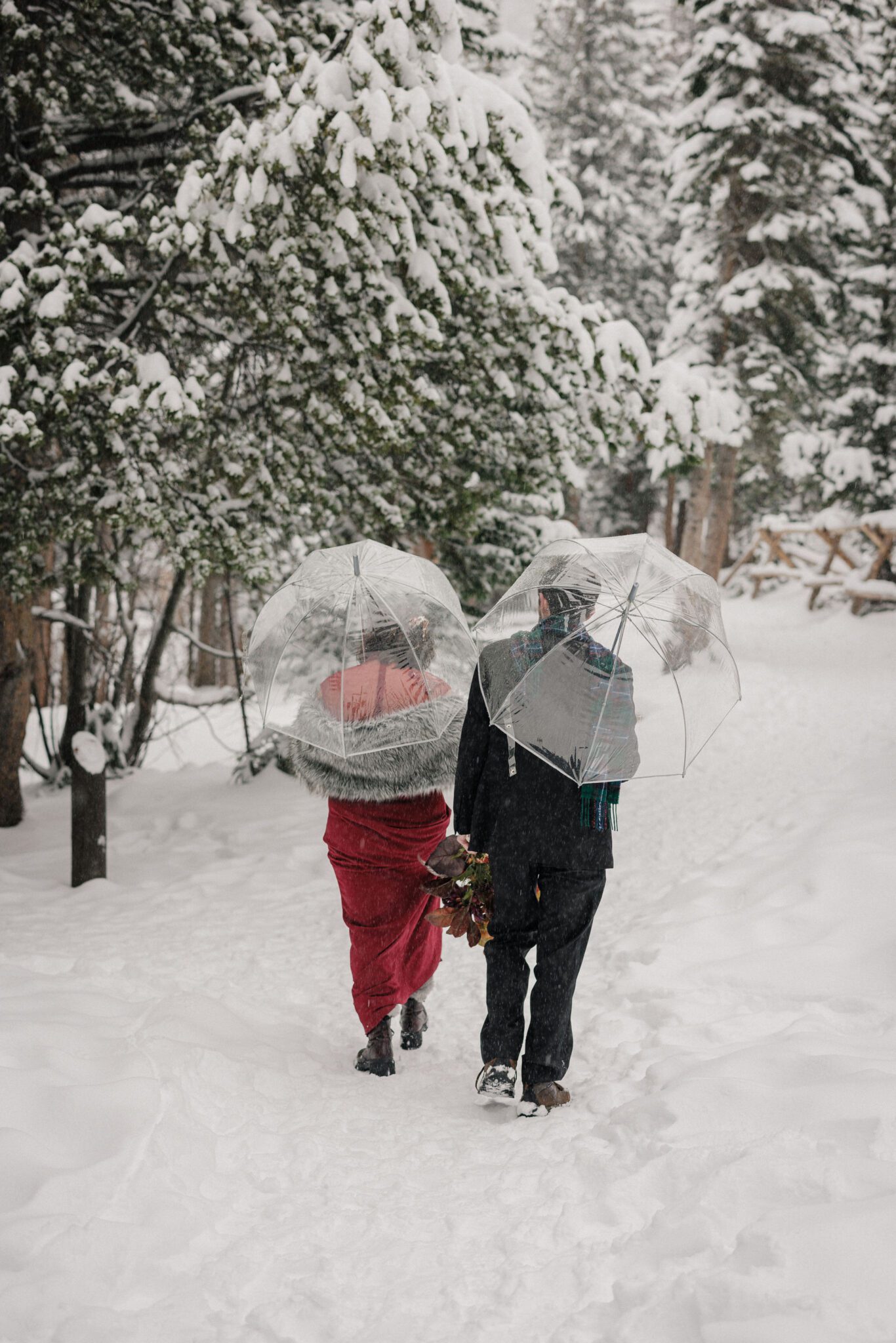 bride and groom walk through snowy trails during elopement at rocky mountain national park
