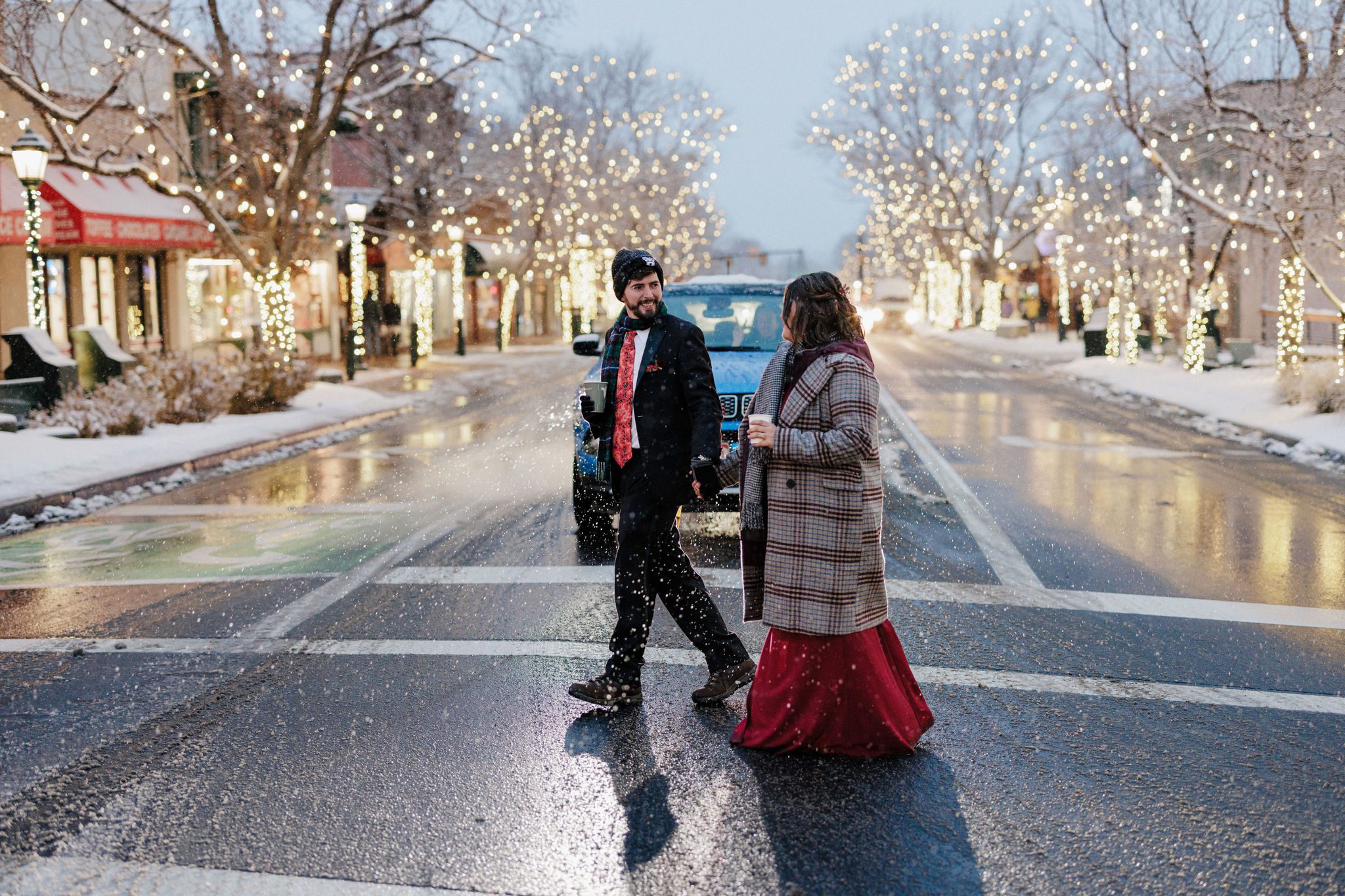 bride and groom hold hands and walk through estes park colorado during winter elopement