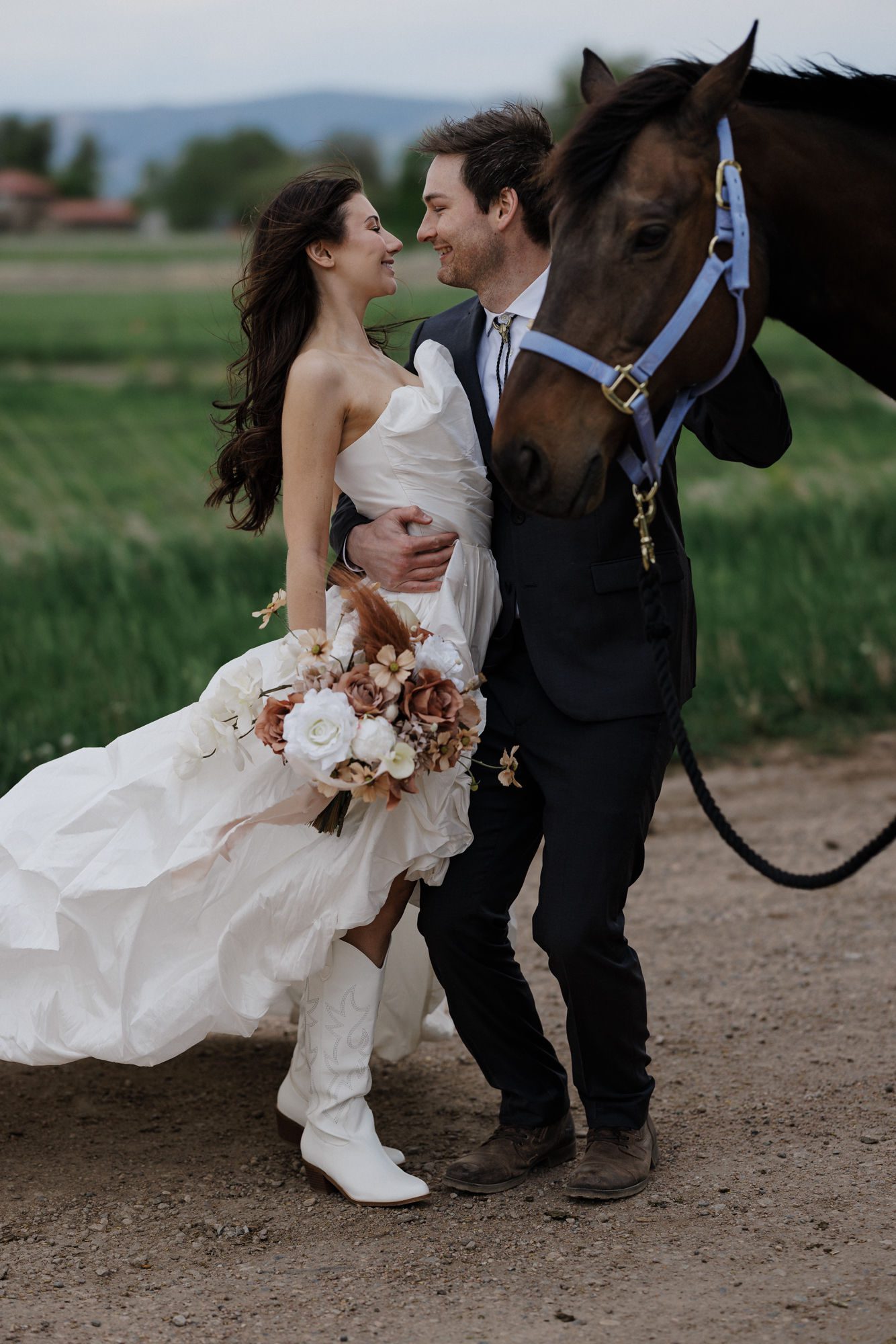 groom grabs bride in a hug and smiles during wedding photos in colorado