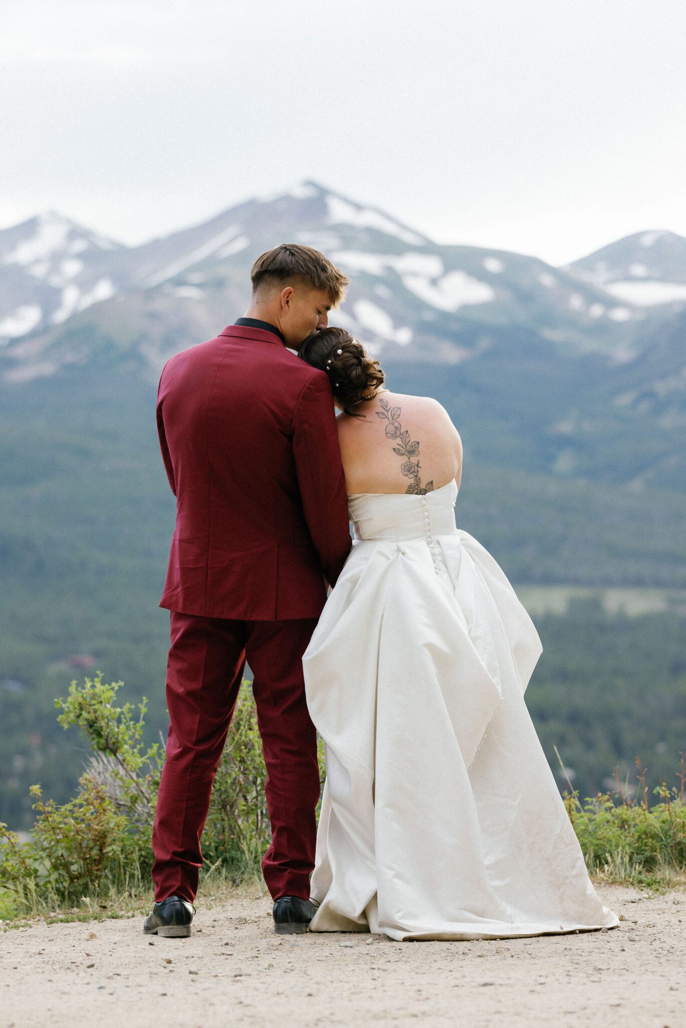 woman leans head on mans shoulder at boreas pass, a popular colorado engagement location, for photos