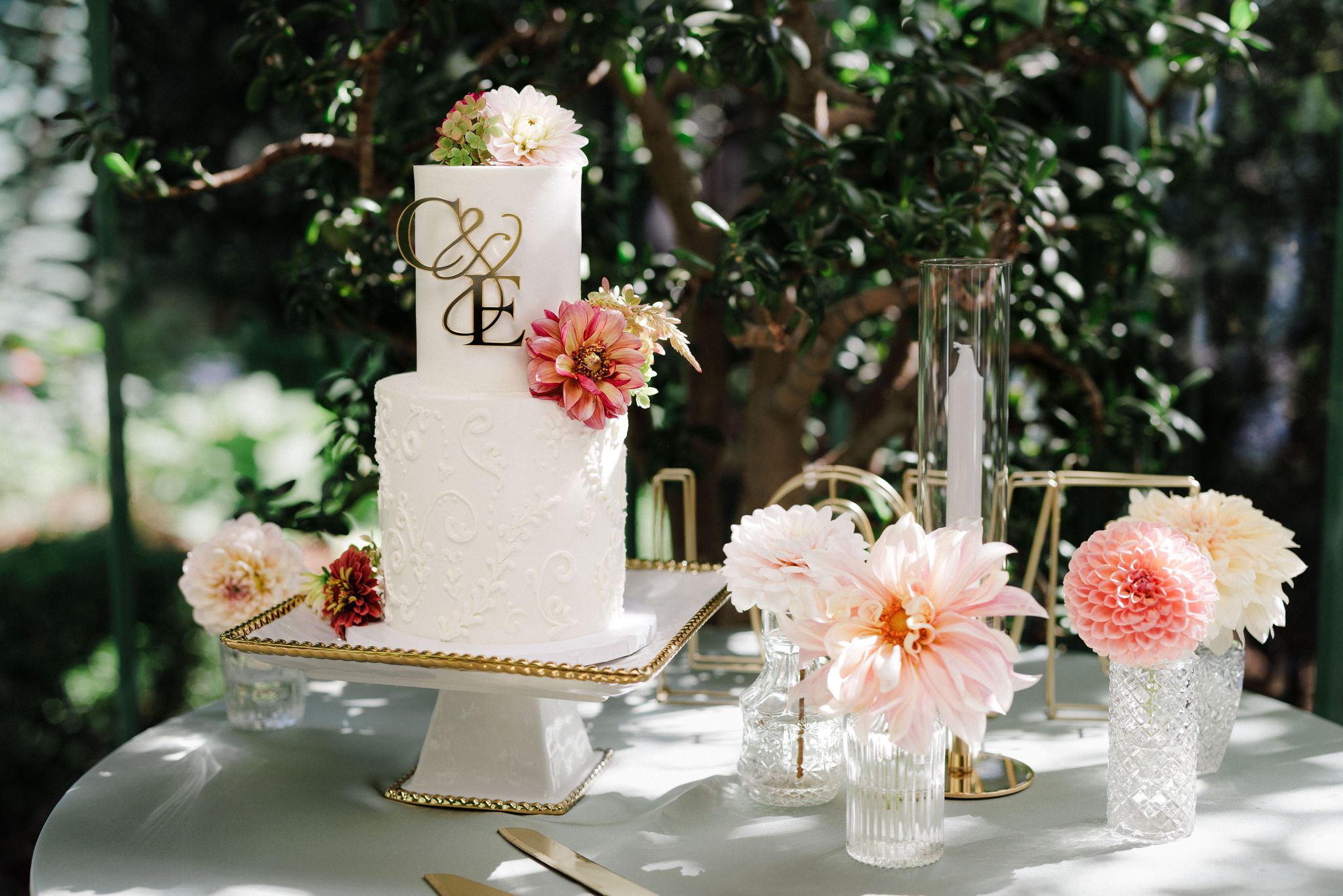 elopement cake sits on table with flowers and greenery