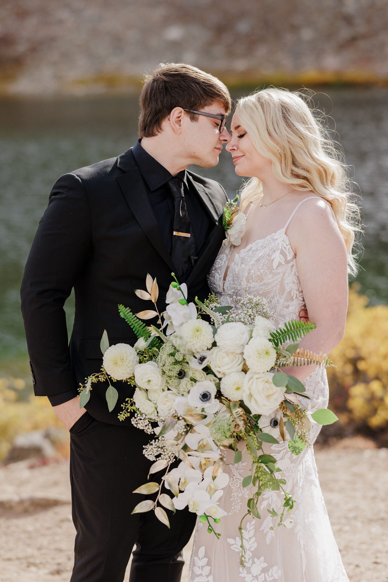 bride and groom pose with floral abouquet made by Colorado elopement vendor, a florist