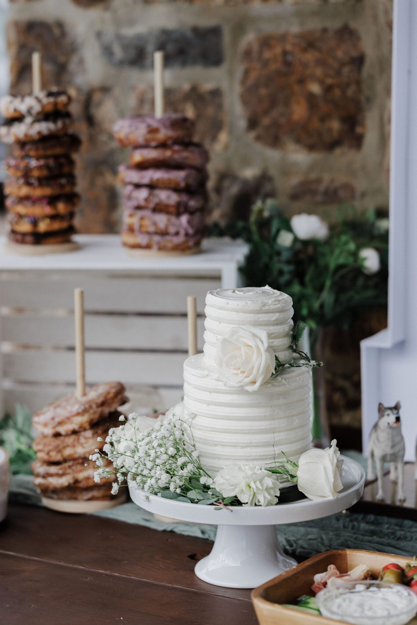 white cake and donuts sit on table for wedding, made by elopement vendor, a baker