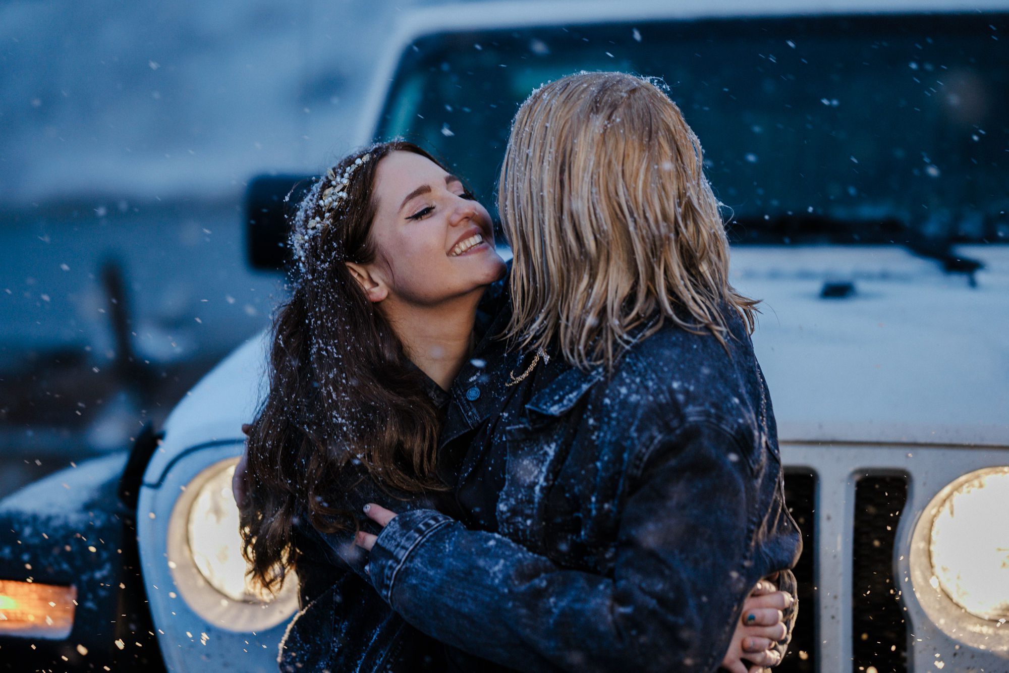 two brides smile and hug in front of jeep during colorado elopement day