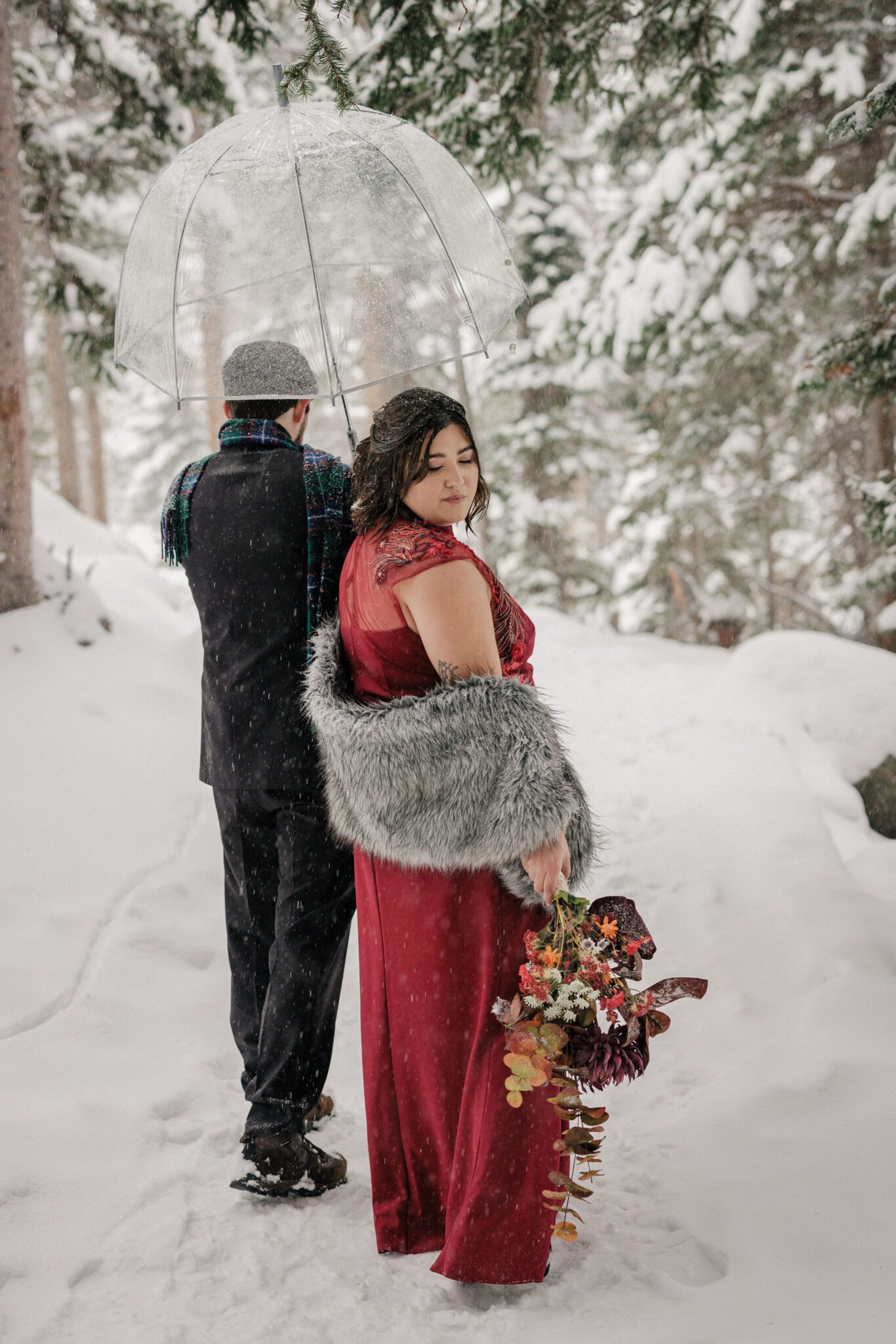 best time to get married: winter- bride and groom walk through snowy trail