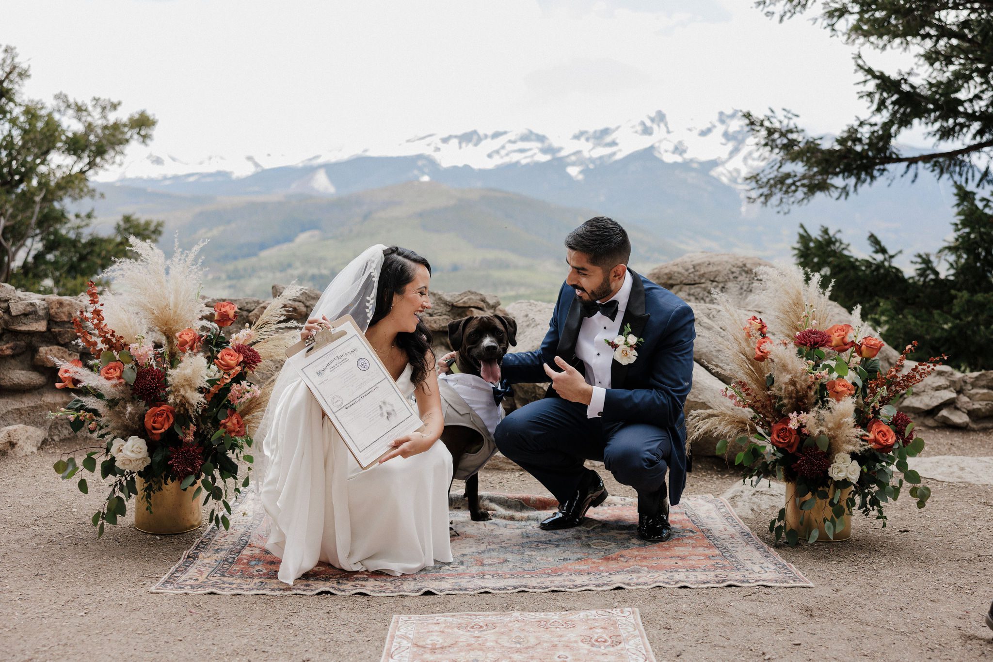 bride and groom smile as they plan a colorado elopement with dog and signs marriage license