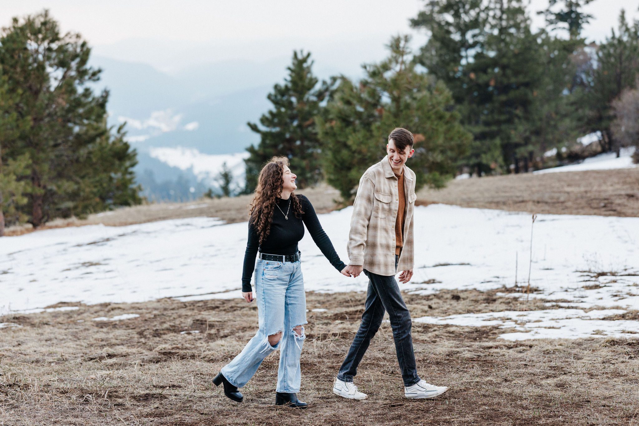 after choosing the best place to propose in colorado, couple holds hands and walks on trail