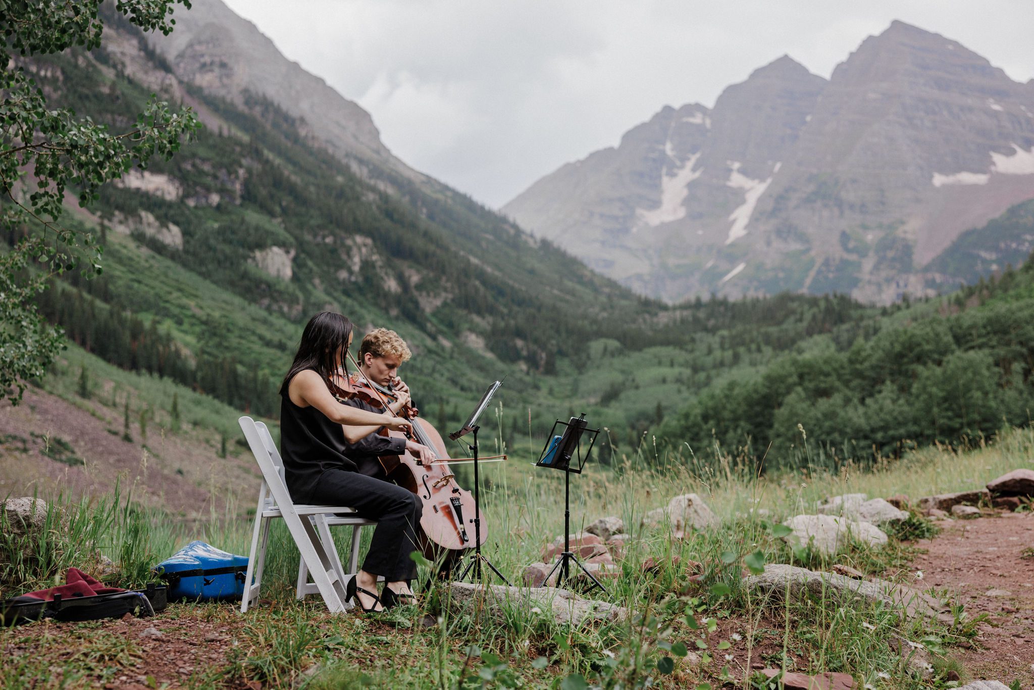 string duo plays in the colorado mountains during colorado elopement at maroon bells