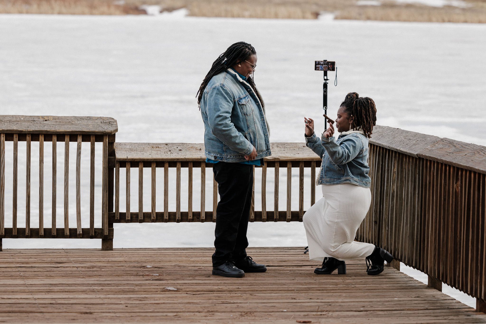 woman gets down on one knee to propose to her partner in colorado