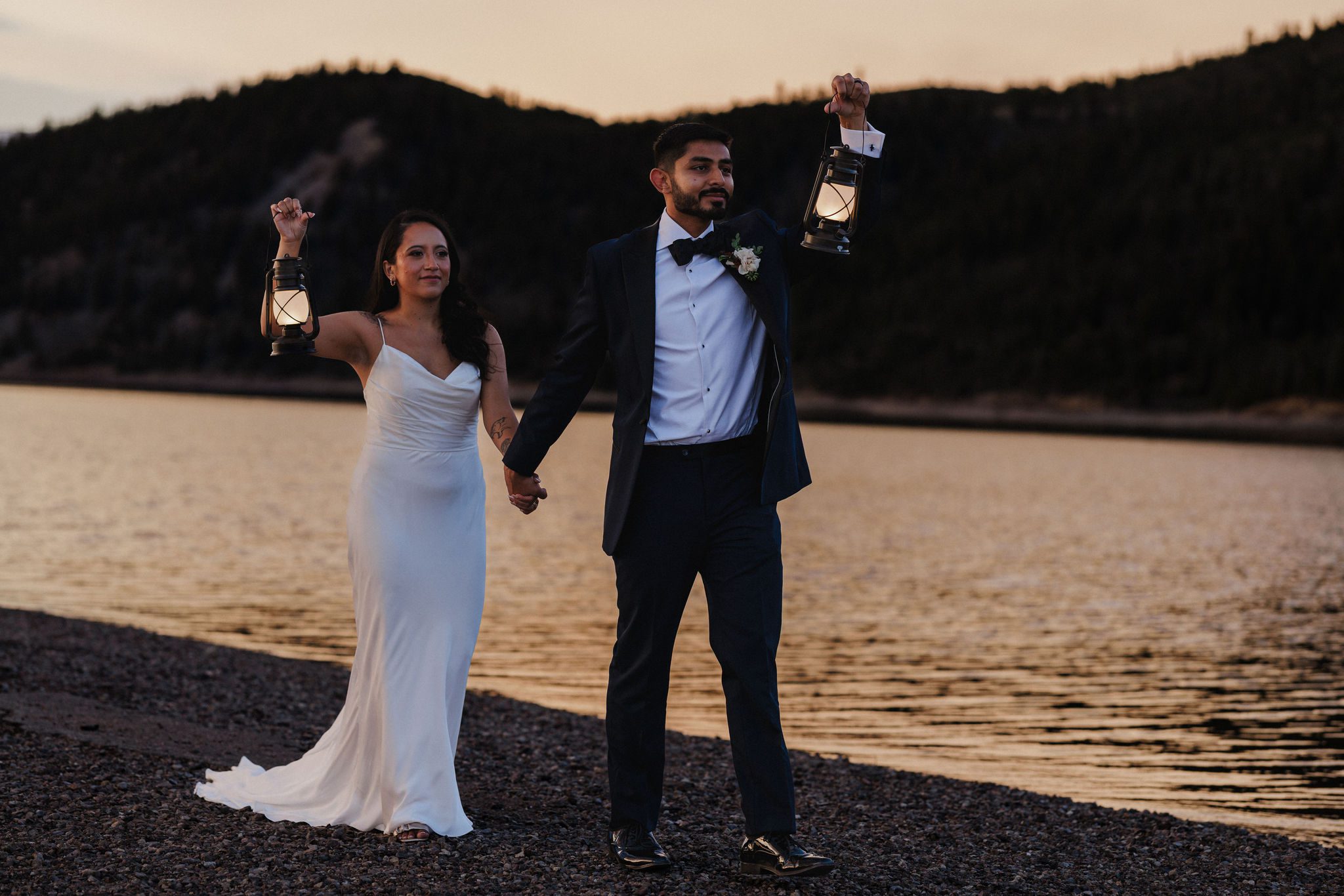 elopement planning: bride and groom walk along lake in colorado during sunset wedding photos