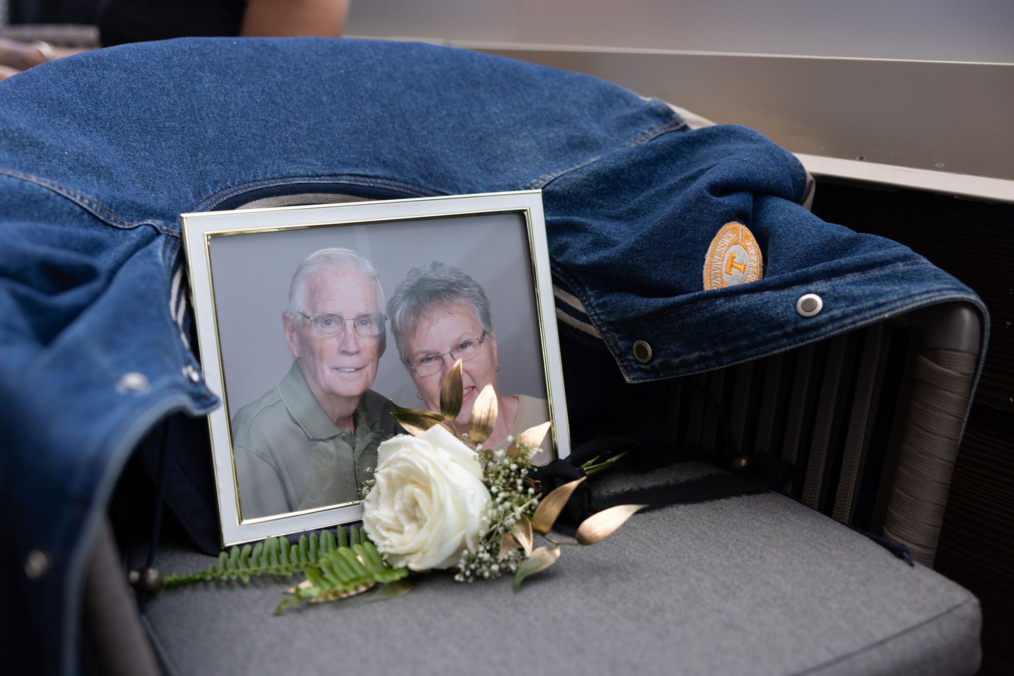 after planning a wedding while grieving, bride and groom reserve an empty chair for passed loved ones