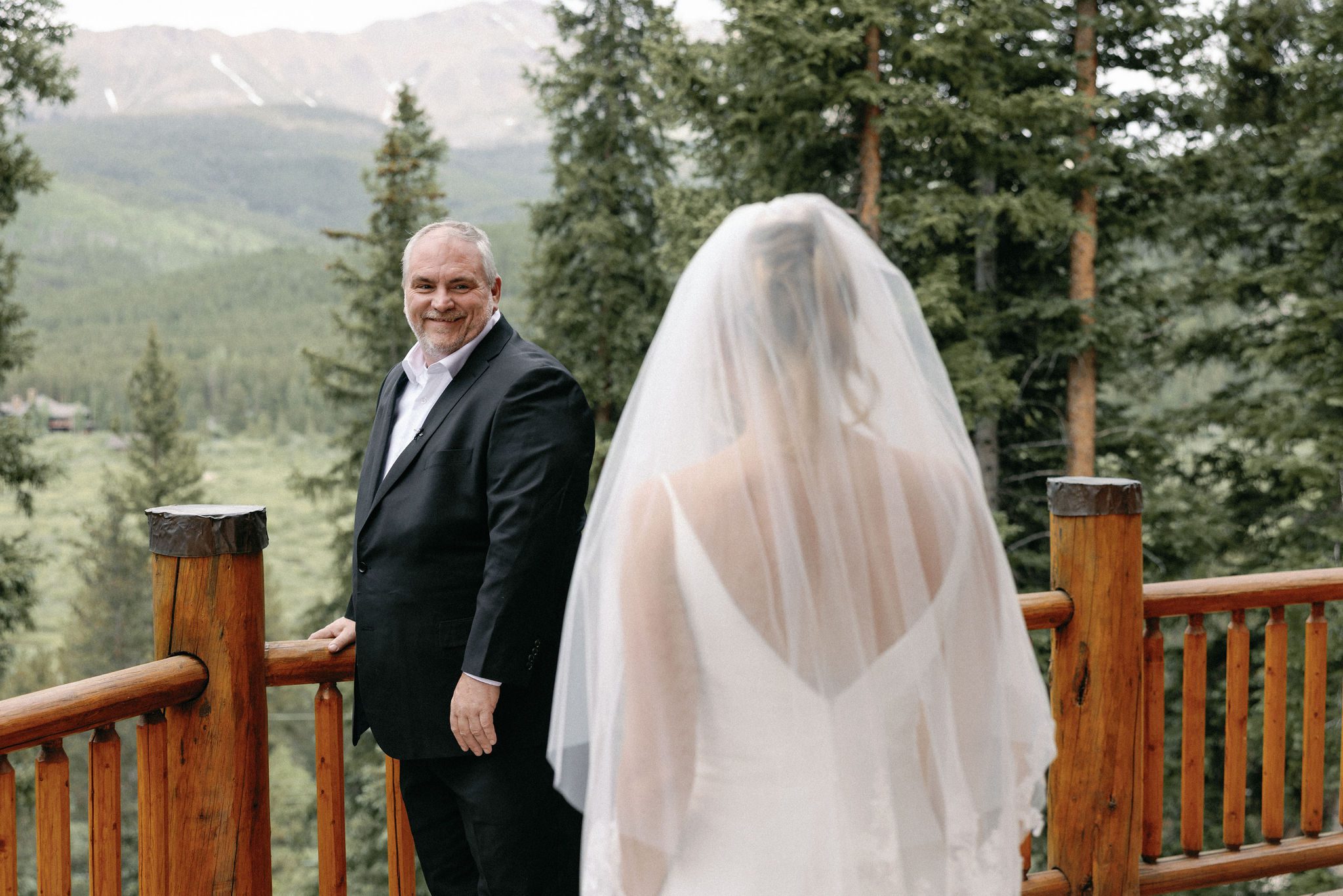 father of the bride turns around and smiles as he sees his daughter for the first time in her wedding attire