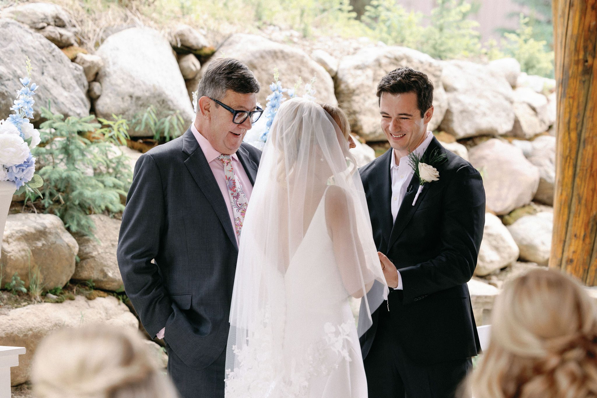 bride and groom smile at each other during their wedding ceremony at the mountain cabin