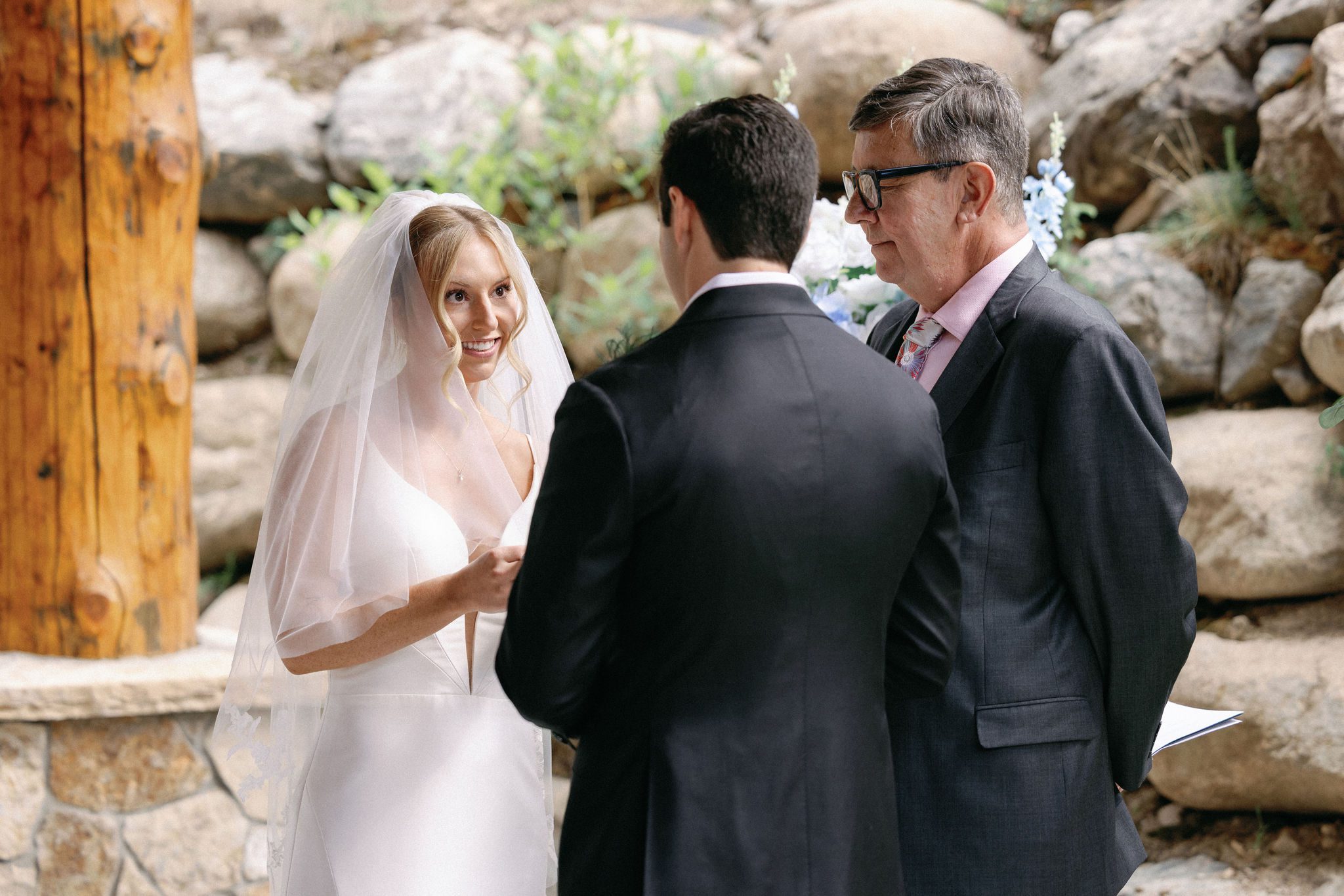bride smiles and looks at groom while reading vows at the airbnb ceremony