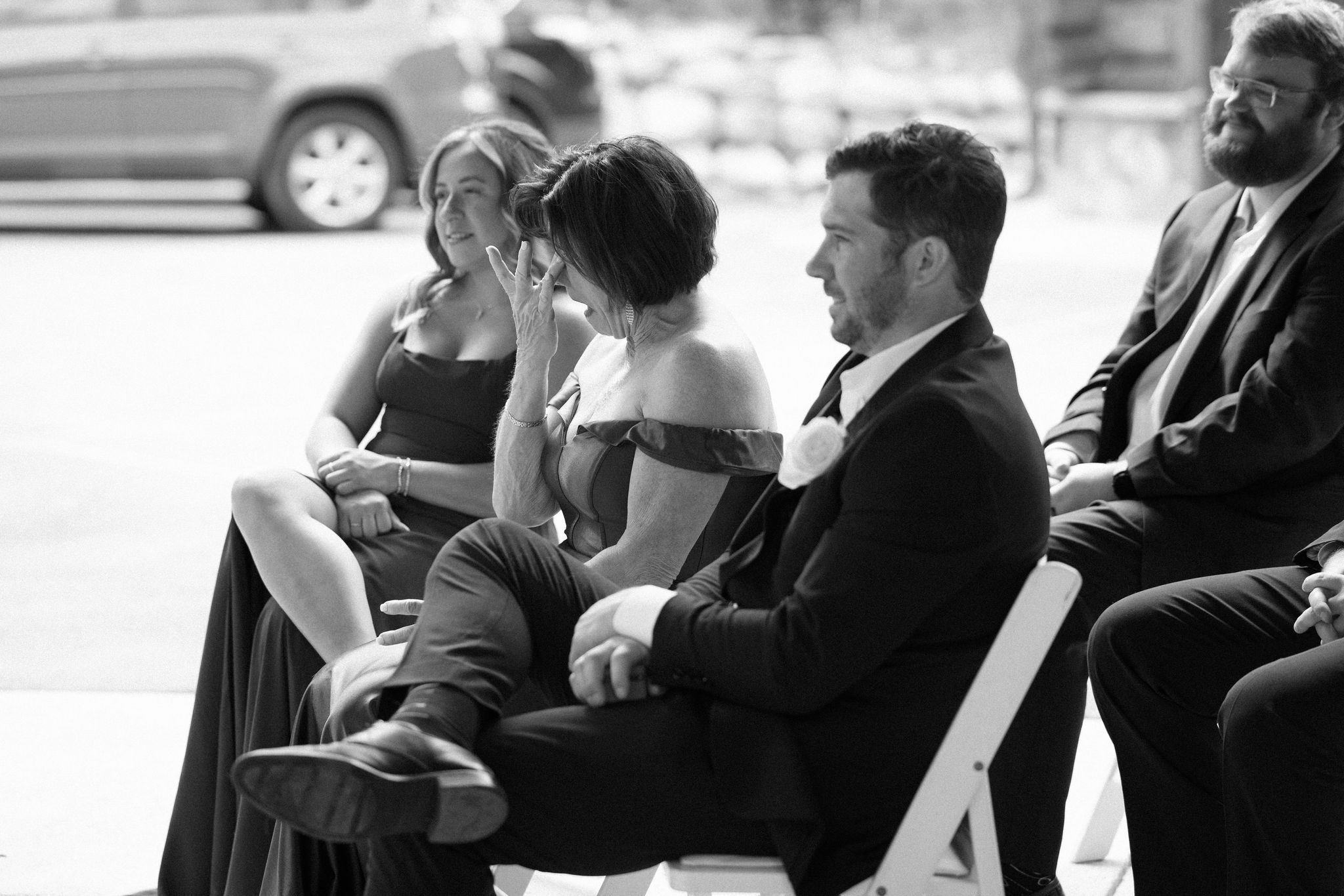 groom's mother wipes away a tear during the wedding ceremony