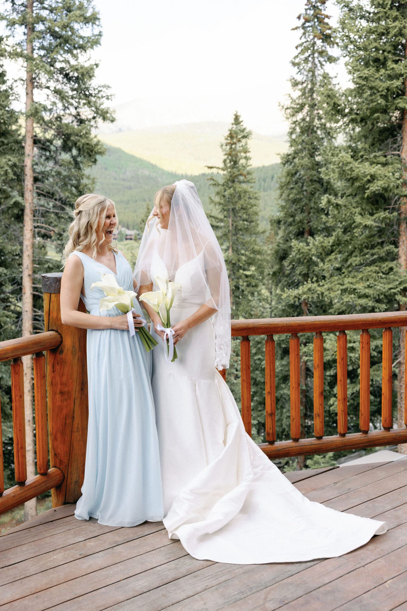 bride smiles at her sister during wedding photos on the deck of the airbnb