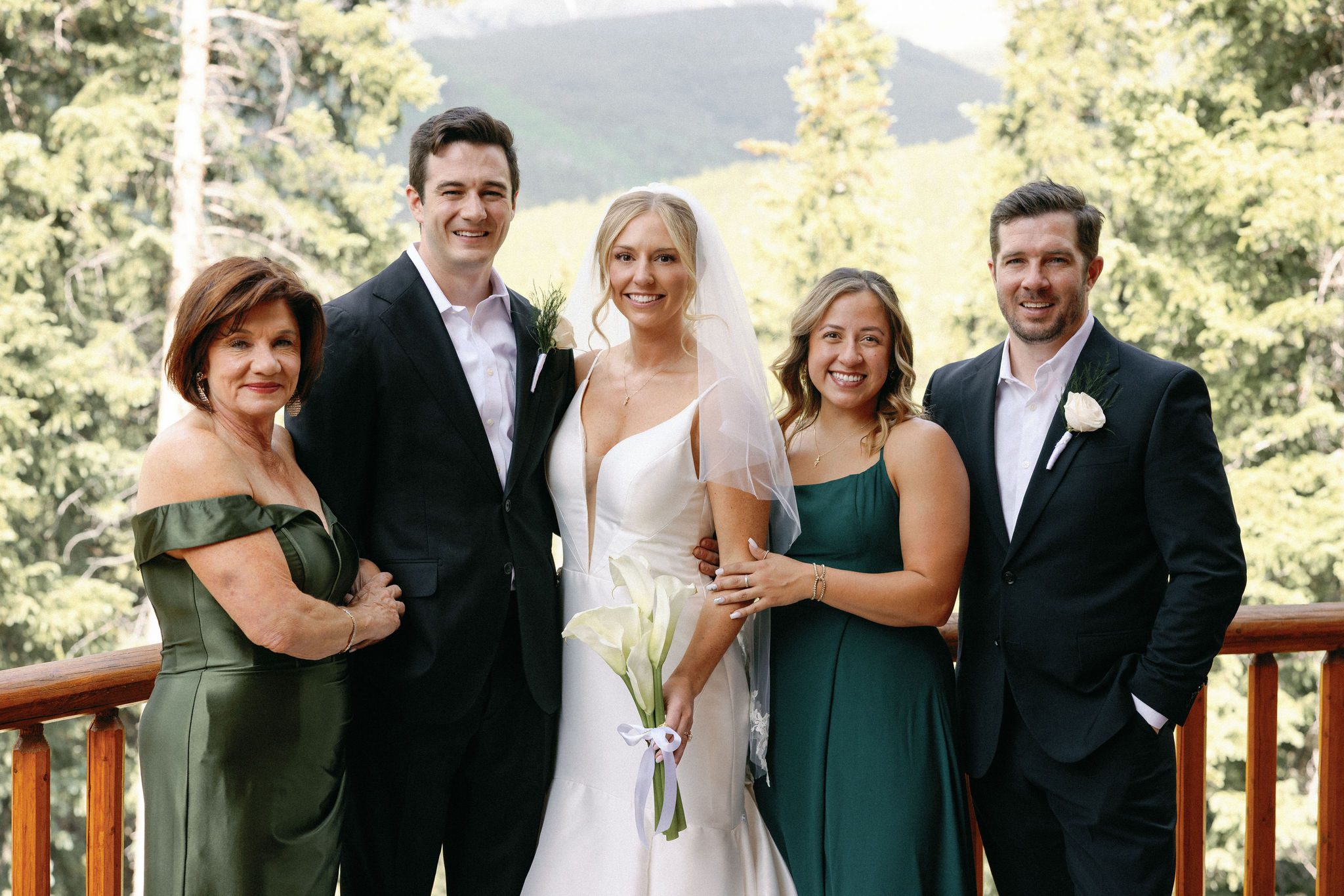 bride and groom smile as theytake family photos