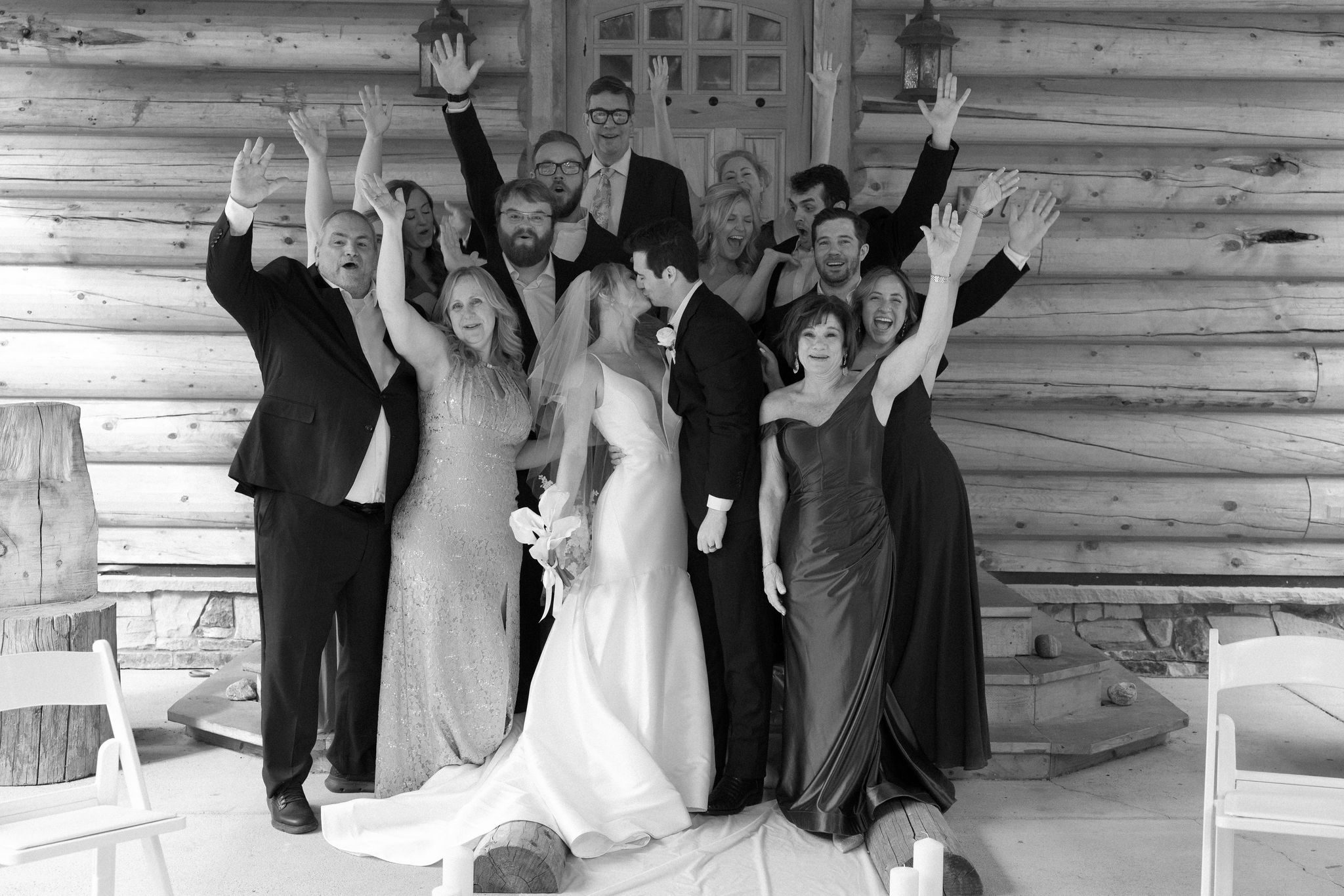 bride and groom kiss, surrounded by all of their guests for their wedding