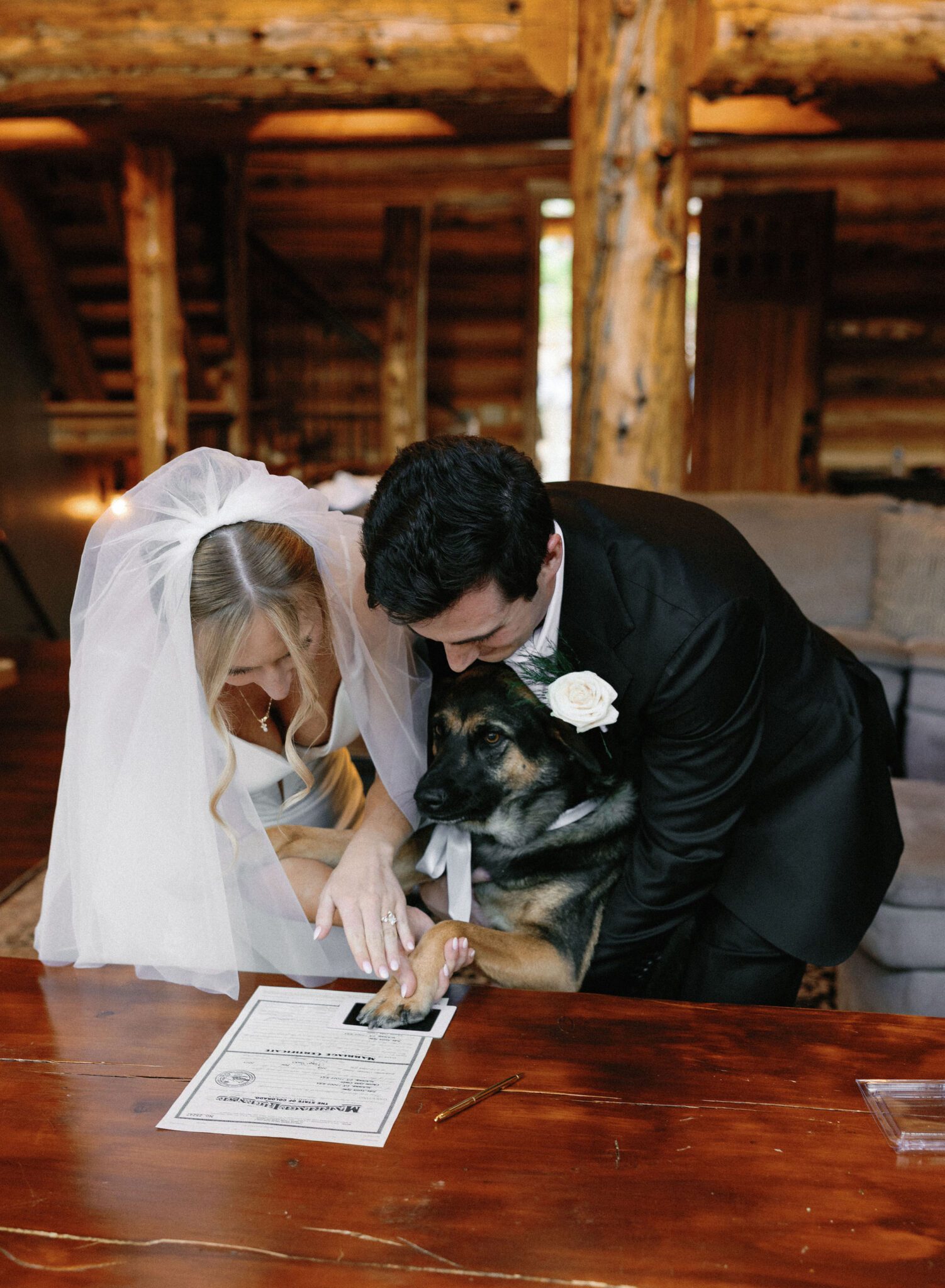 bride and groom help their dog sign their colorado marriage license with a messless inkpad