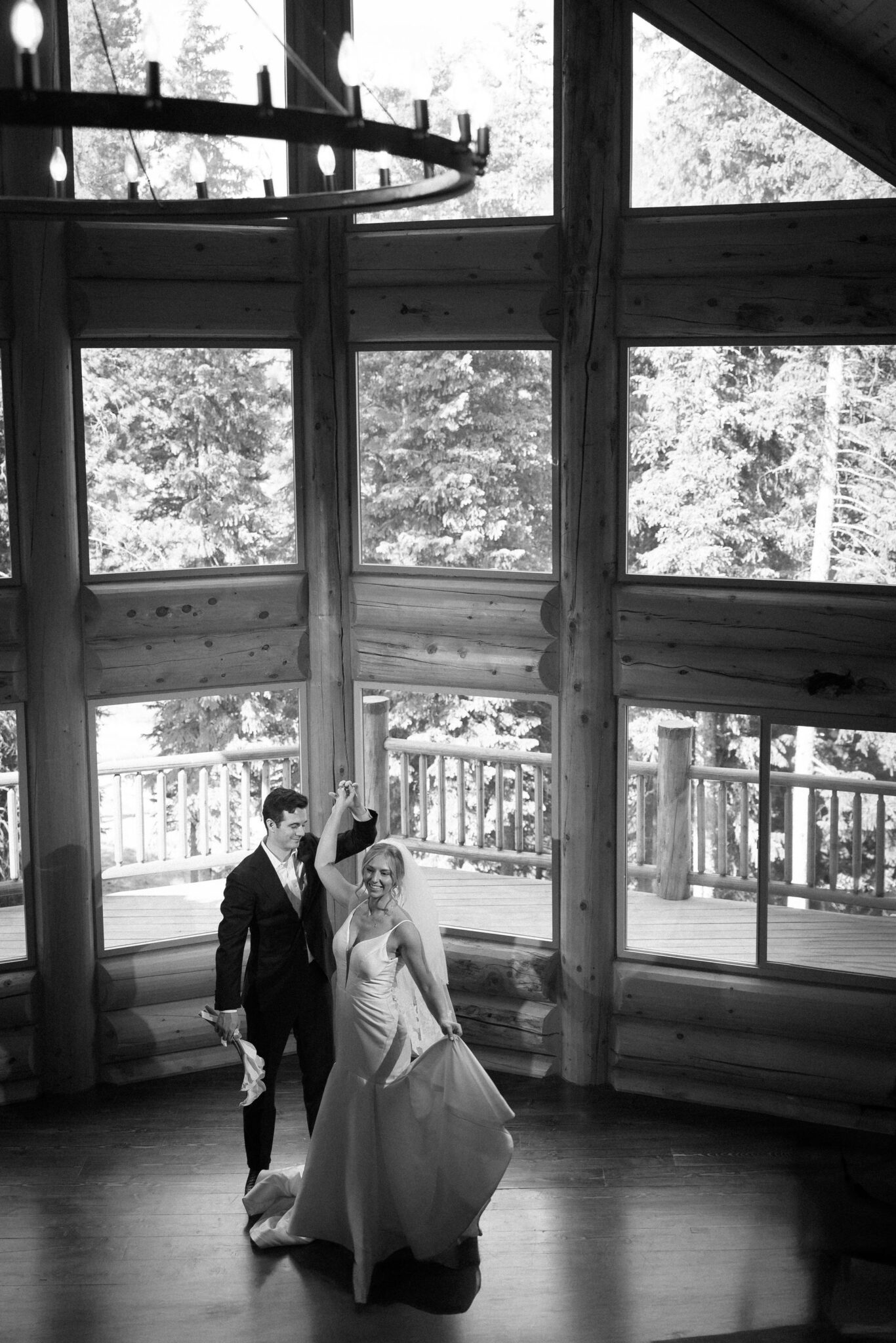 bride and groom dance in front of the large window of the airbnb during wedding photos