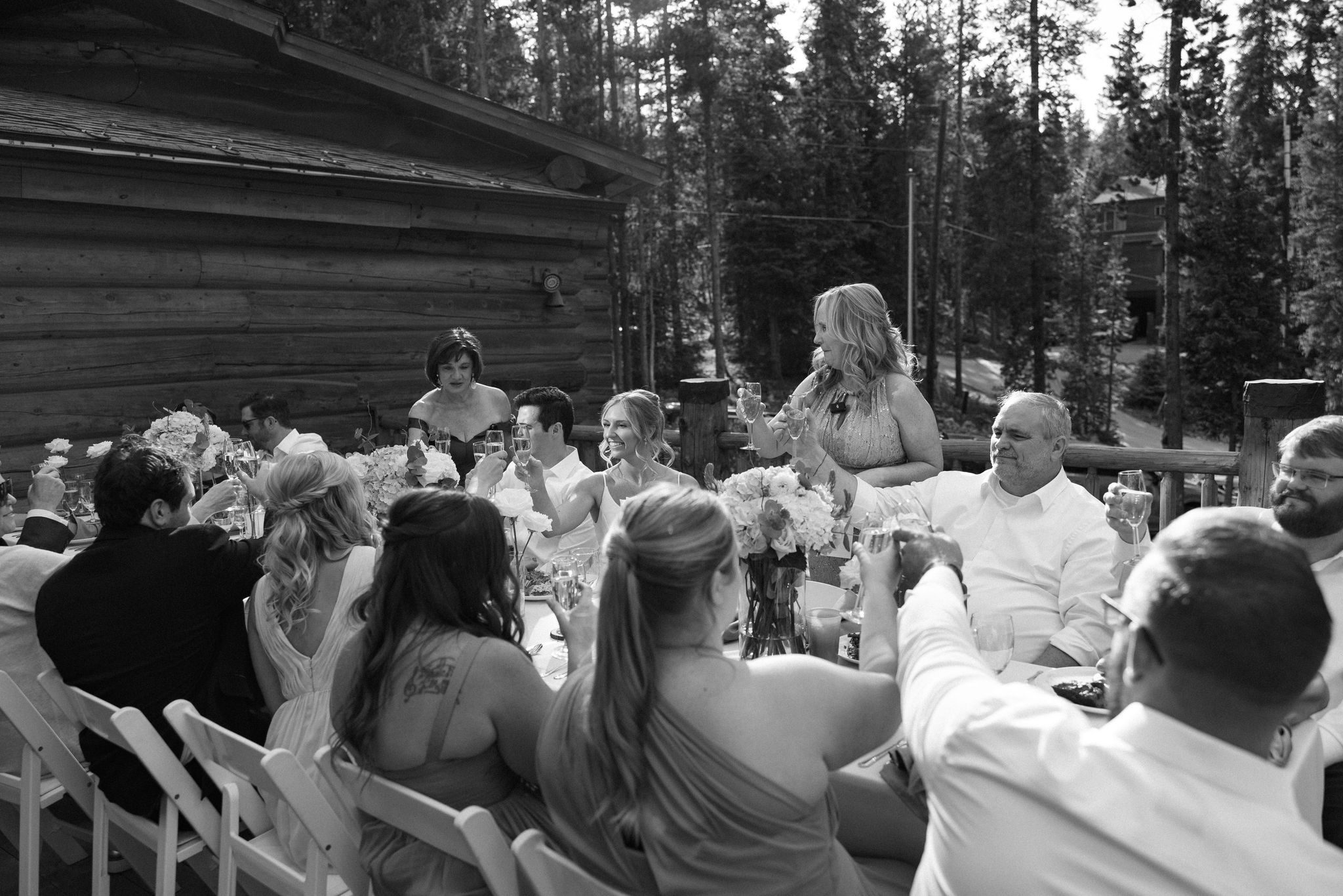 wedding guests raise glasses and toast during the wedding reception on the deck of the airbnb
