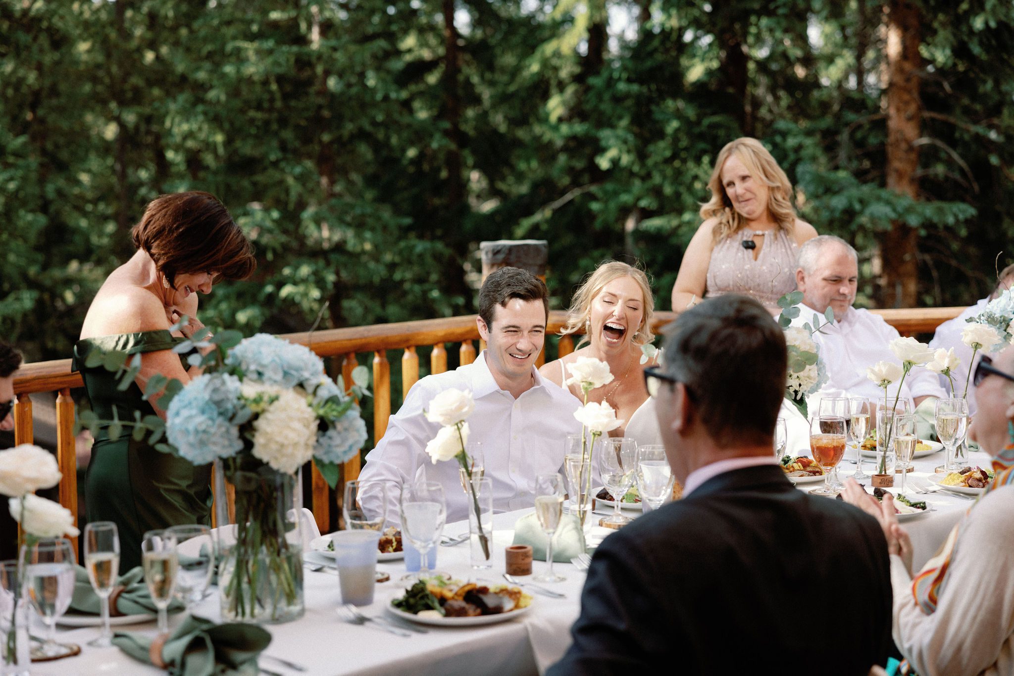 bride and groom laugh during wedding reception toasts on the deck of the airbnb
